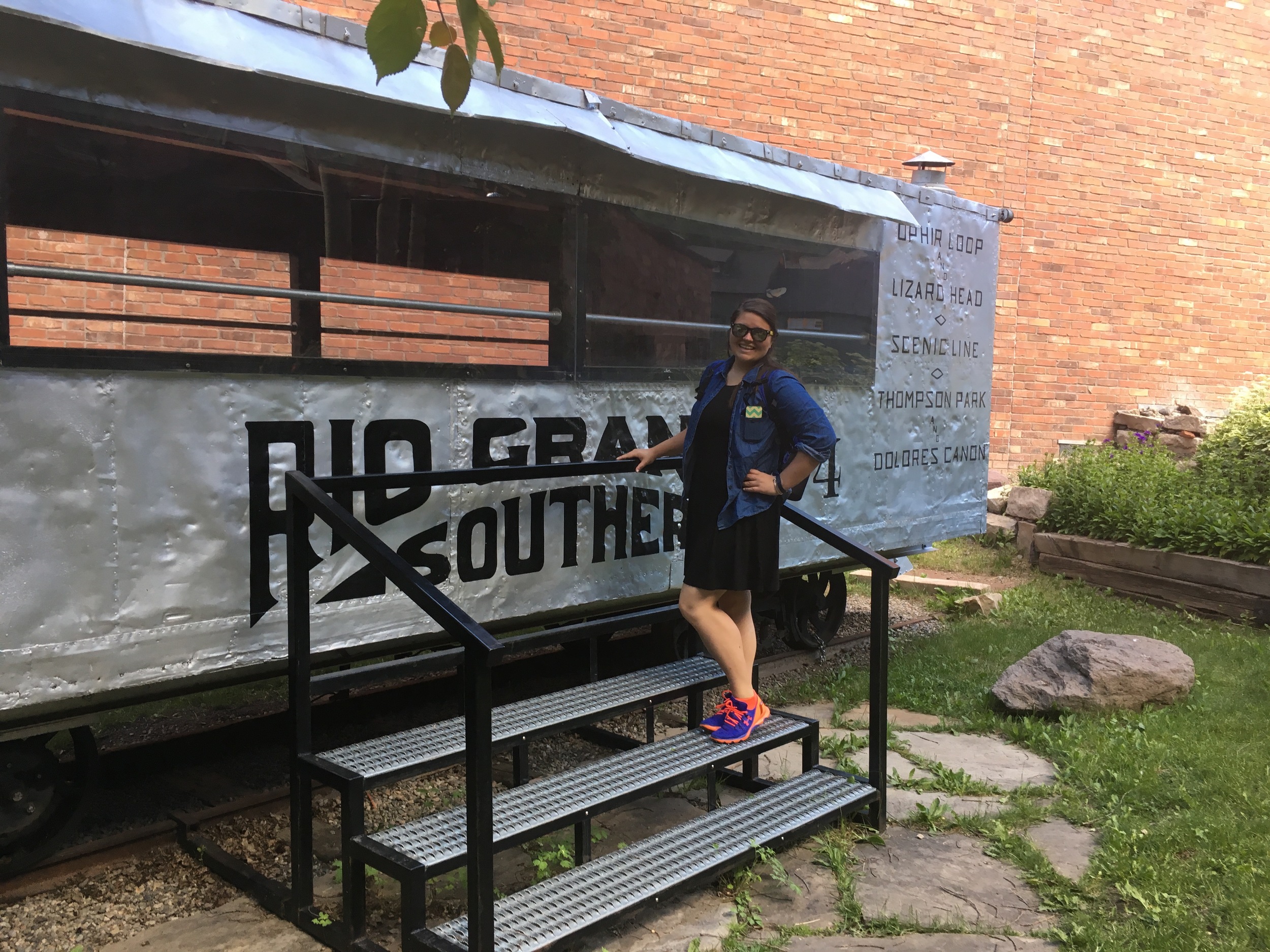 Kara poses with an old train car from the Rio Grande service line.
