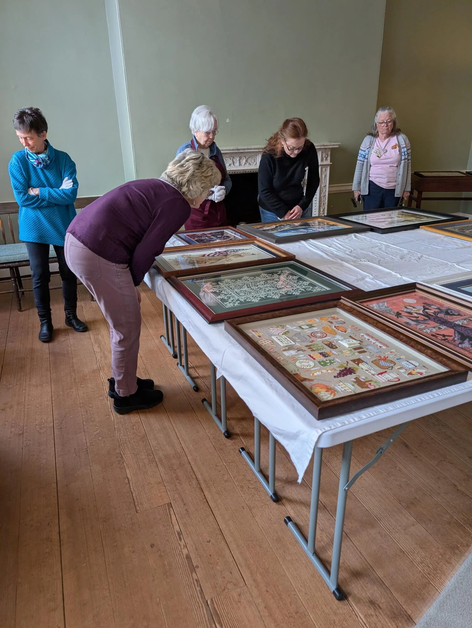 Visitors examining needlework pieces