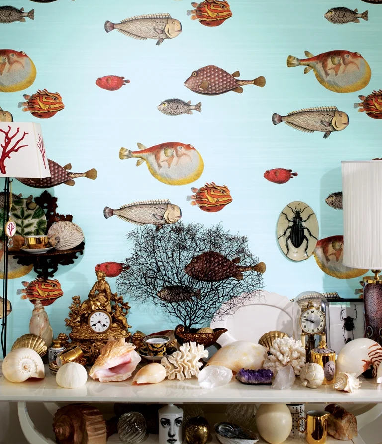WHIMSICAL CLOWN FISH ARE FROM COLE & SON'S ACQUARIO FORNASITTI II. THE WALL COVERING CREATES A DRAMATIC BACKDROP FOR AN ENTRY TABLE STYLED WITH FAVORITE BEACH-INSPIRED PIECES. PHOTO: COLE & SONS.
