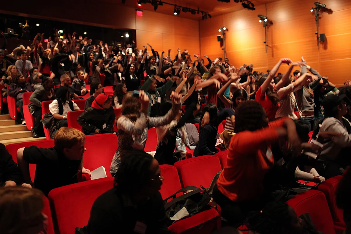 Audience doing wave at TED Youth
