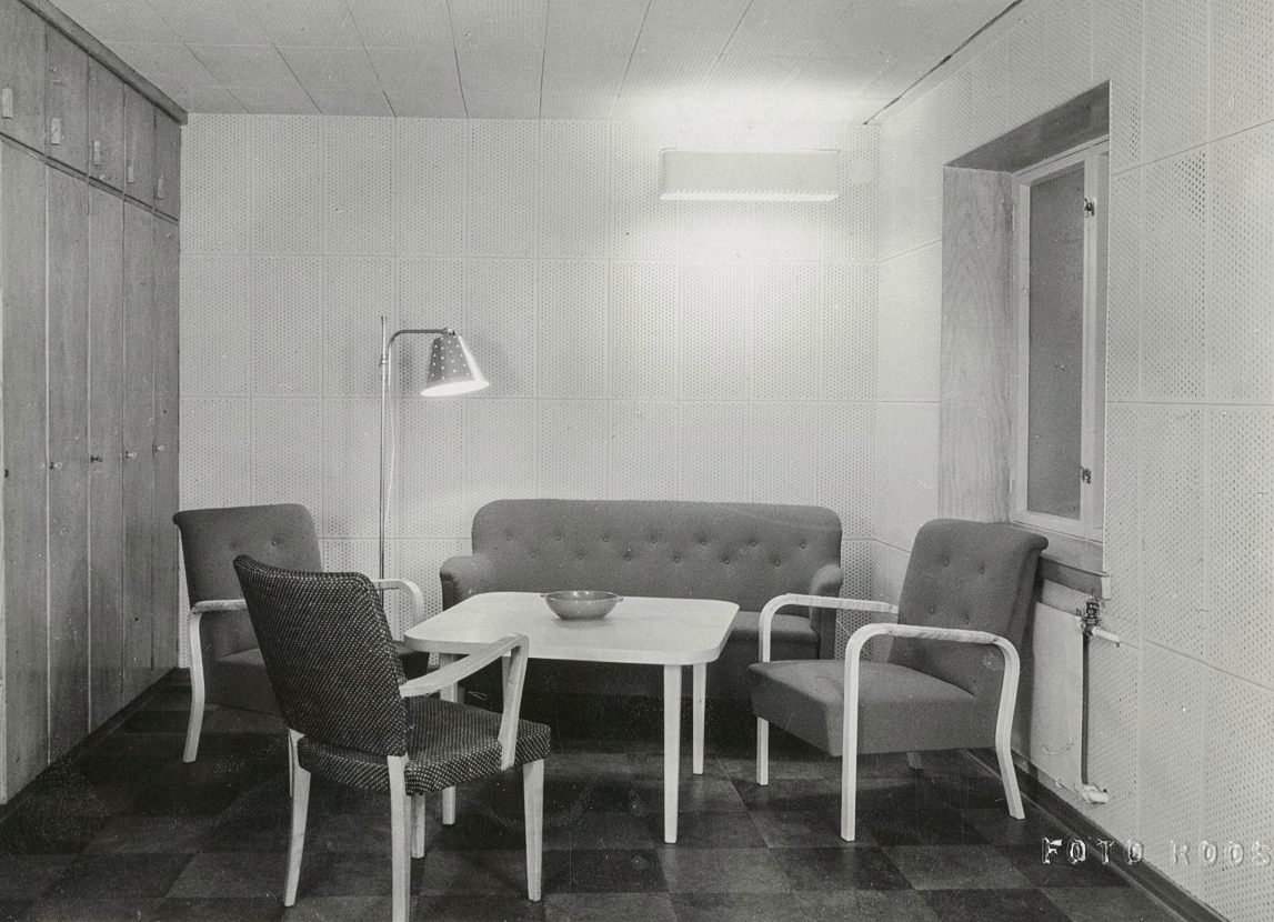 Lobby room at the Archive of National Poetry after renovation in 1950, architect Paavo Riihimäki. Brass floor lamp and perforated ceiling lamp by Paavo Tynell and Taito Oy. Image copyright by SKS.
