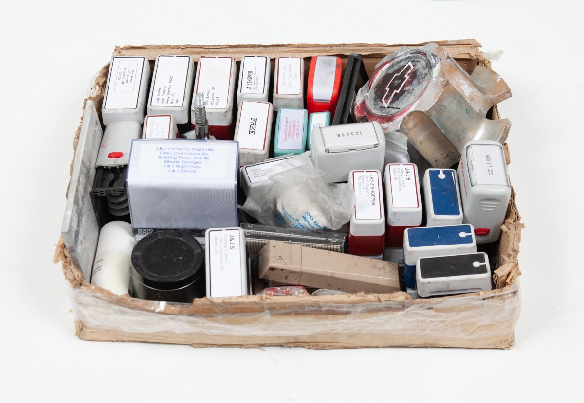   Untitled (Stamp Collection)  . 2014 - ???  Self-Inking Stamps; Ink; Toner; Wooden Stamps; Cardboard; and Found Objects including Portable Speaker; Georgia Clay; Plastic (Spectrum); Metal; Hub Cab (J &amp; J Flea Market); Arby’s Berry Bronco Sauce (