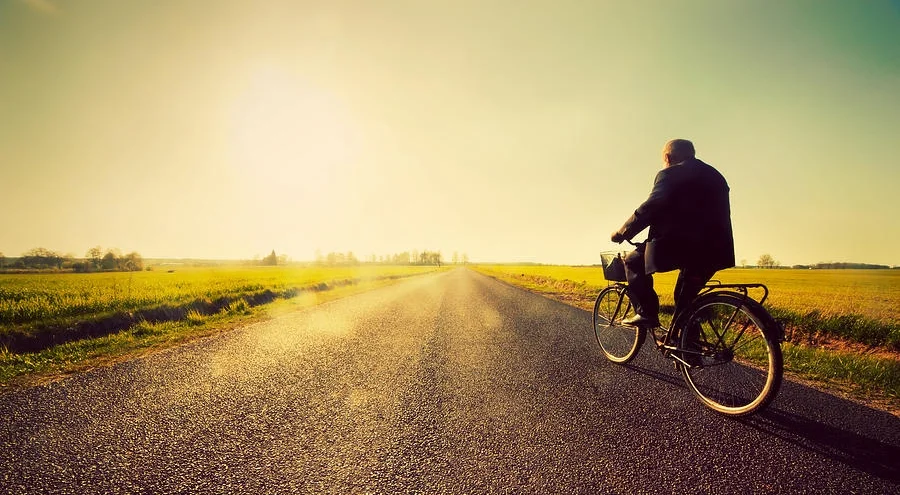 old-man-riding-a-bike-to-sunny-sunset-sky-michal-bednarek.jpg