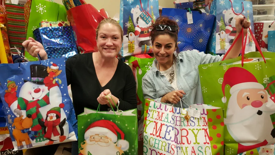 leigh and mouna packing bags for cumac's holiday wish list program