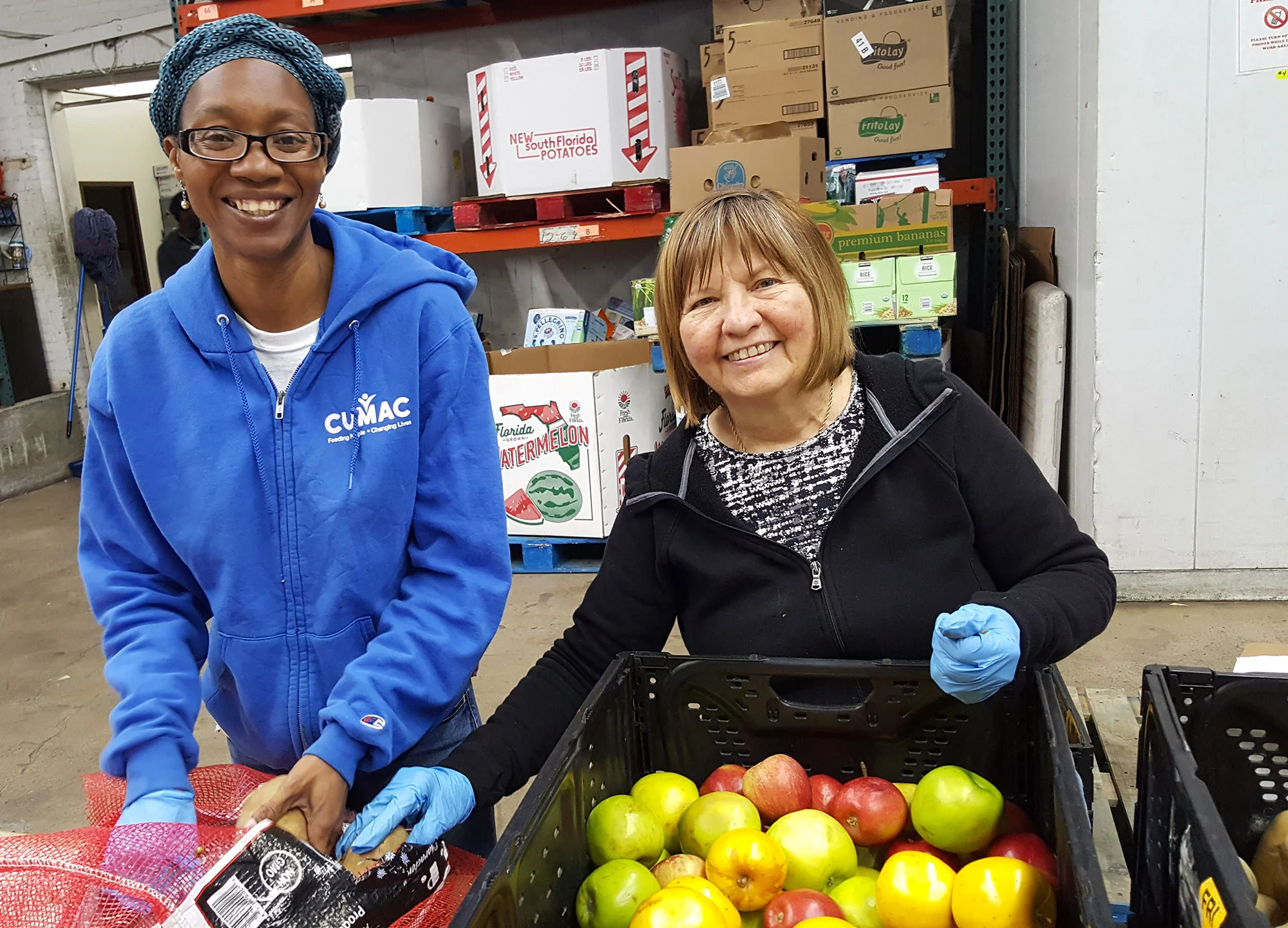 Kayann working with a volunteer on one of CUMAC’s daily sorting projects in our warehouse.