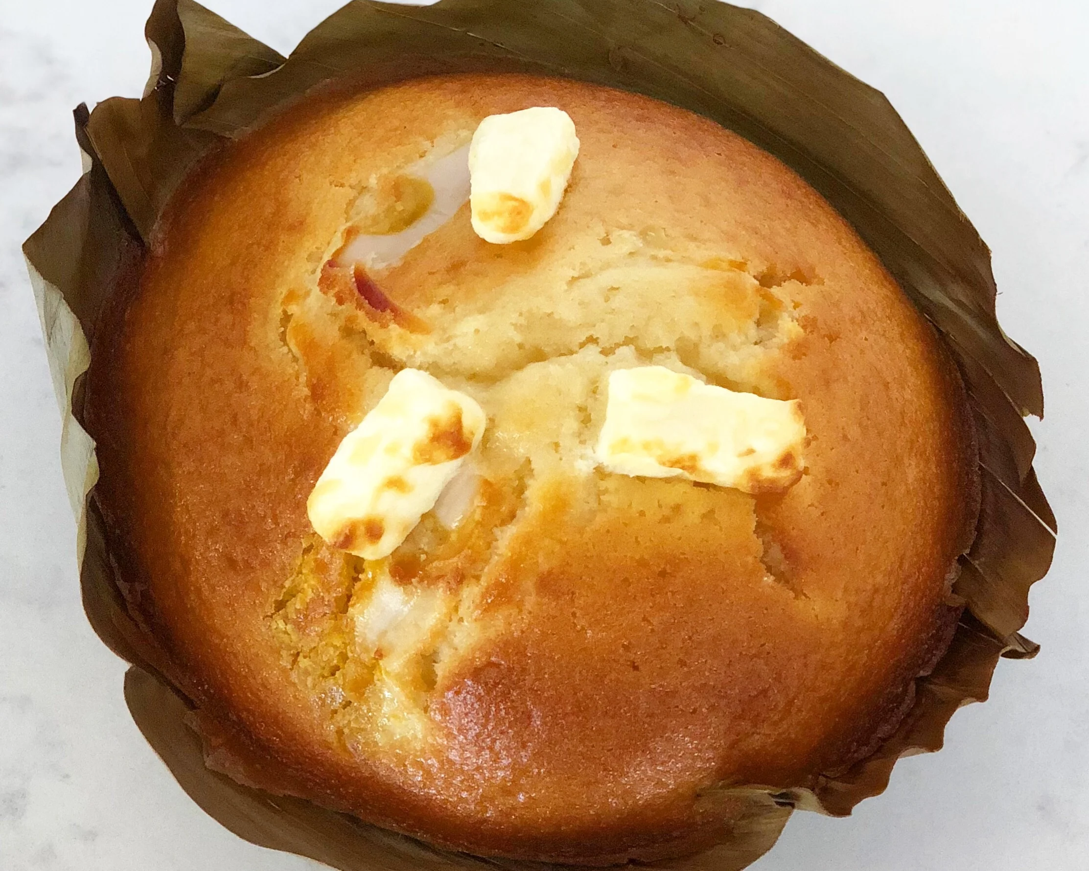 BIBINGKA Traditional Filipino snack cake made with rice, coconut milk, and chopped salted egg. Baked in a banana leaf.