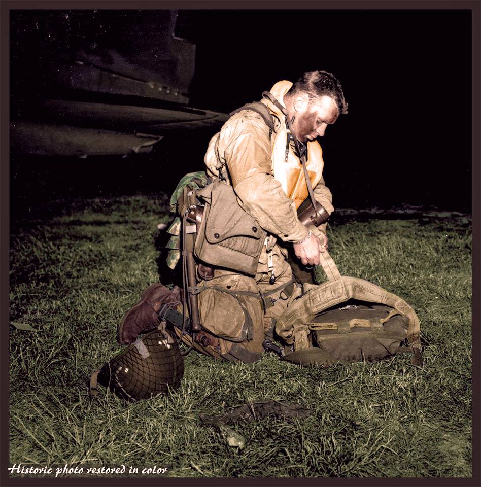 Lt. Col. Robert Wolverton, C/O 3 Btn, 506 Parachute Infantry Regiment, 101st Airborne Division, checking his gear before boarding the C-47 "Dakota", 8Y-S, "Stoy Hora" of the 440th Troop Carrier Squadron at an airfield in Exeter, England. The evening of the 5th of June 1944. On that evening in June 1944, he gathered his men in an orchard adjacent to what is now Exeter airport, and said: "Men, I am not a religious man and I don't know your feelings in this matter, but I am going to ask you to pray with me for the success of the mission before us. And while we pray, let us get on our knees and not look down but up with faces raised to the sky so that we can see God and ask his blessing in what we are about to do. "God almighty, in a few short hours we will be in battle with the enemy. We do not join battle afraid. We do not ask favors or indulgence but ask that, if You will, use us as Your instrument for the right and an aid in returning peace to the world. "We do not know or seek what our fate will be. We ask only this, that if die we must, that we die as men would die, without complaining, without pleading and safe in the feeling that we have done our best for what we believed was right. "Oh Lord, protect our loved ones and be near us in the fire ahead and with us now as we pray to you." Sadly, within hours, the orator himself was dead; a cruel twist of fate meant his feet never touched French soil. Lt Col Robert L Wolverton (aged 30), was killed by ground fire and left suspended by his parachute from an apple tree in an orchard just north of the hamlet of St Côme du Mont in Normandy. (Nb. of the 15 men in his 'stick', 5 were KIA on D/Day, 8 taken as POWs and 2 unaccounted for) (Colourised by Johhny Sirlande from Belgium)