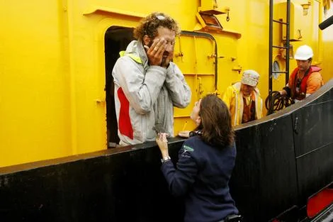 Ten months alone at sea … exhausted rower Alexandro Bellini arrives in Newcastle via tugboat. Photo: Brock Perks