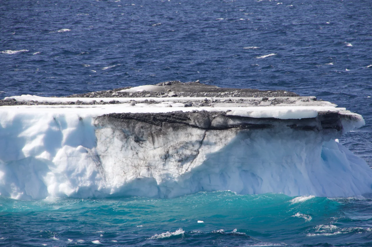 An iceberg transferring debris to the ocean. Credit: Allison Jacobel