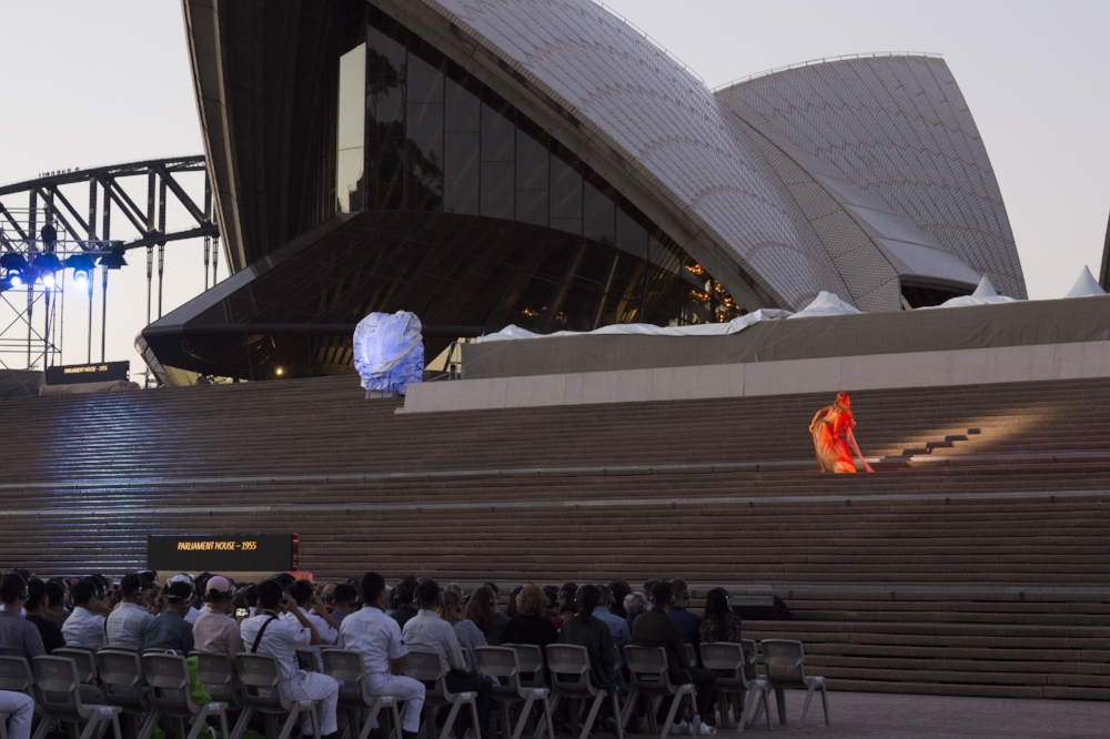 A performer on the Opera House steps at dusk makes for an ethereal sight.