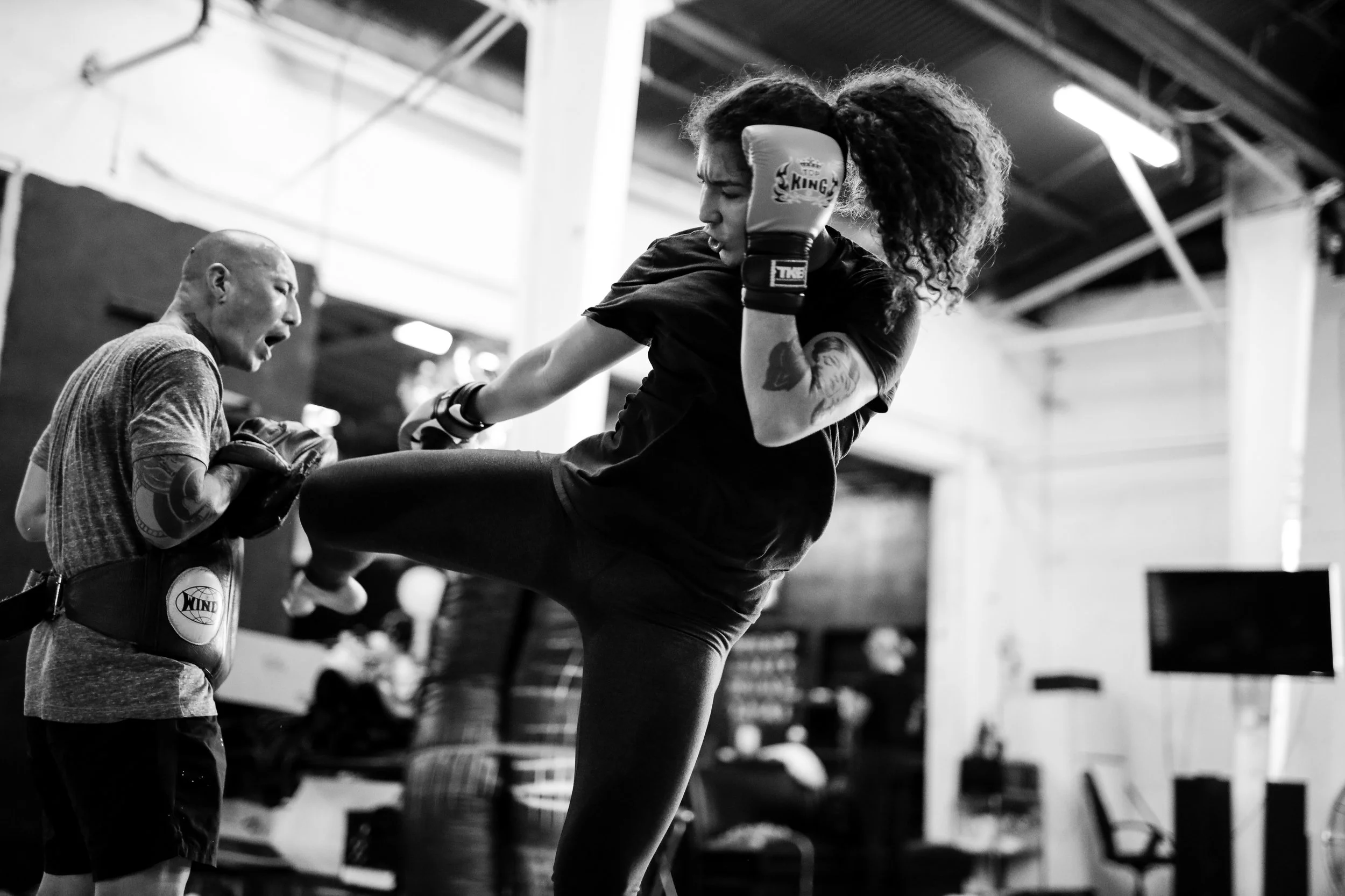 muay thai female fighter hitting pads