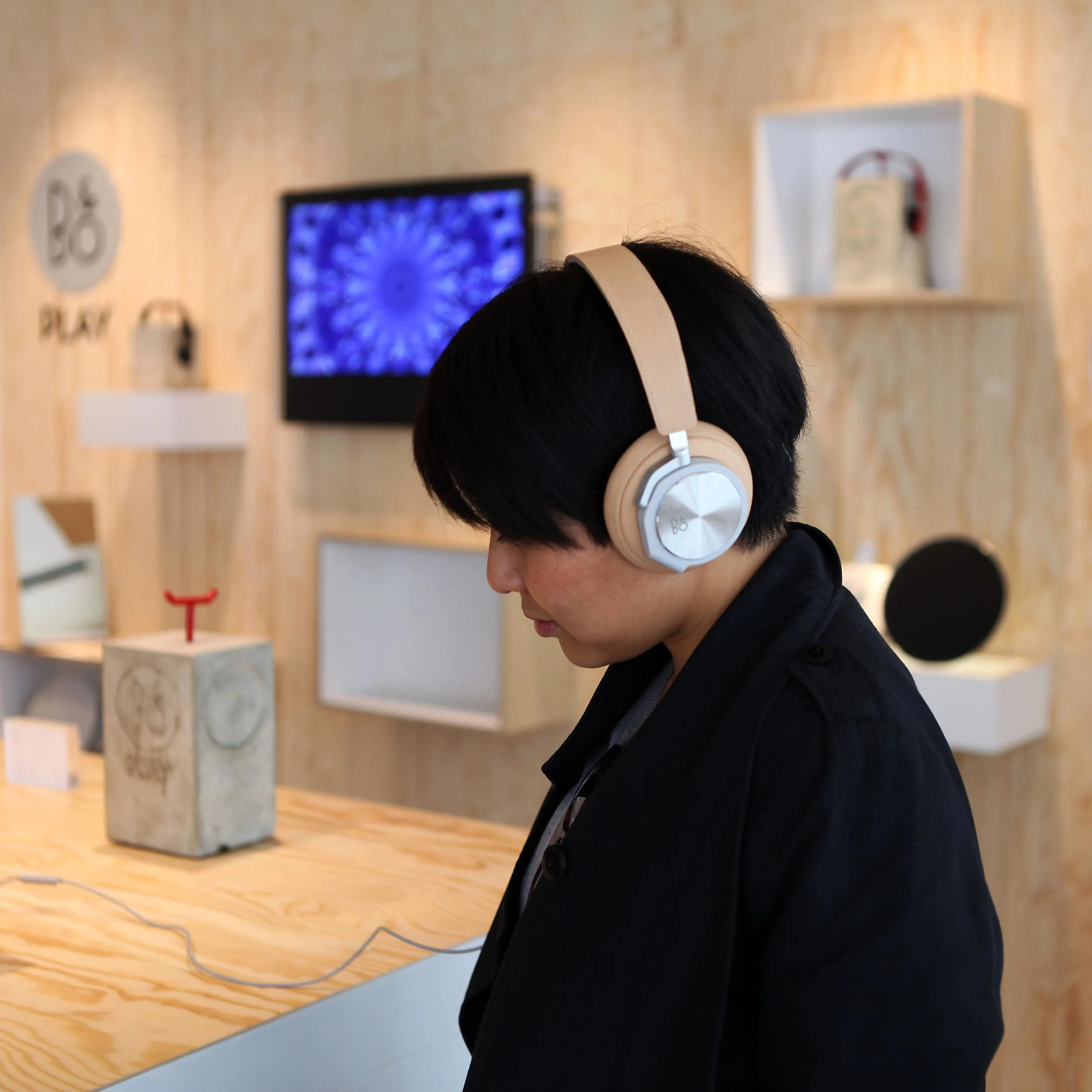 Man listening to a B&O PLAY product in a store constructed according to the shop-in-shop concept by Johannes Torpe Studios
