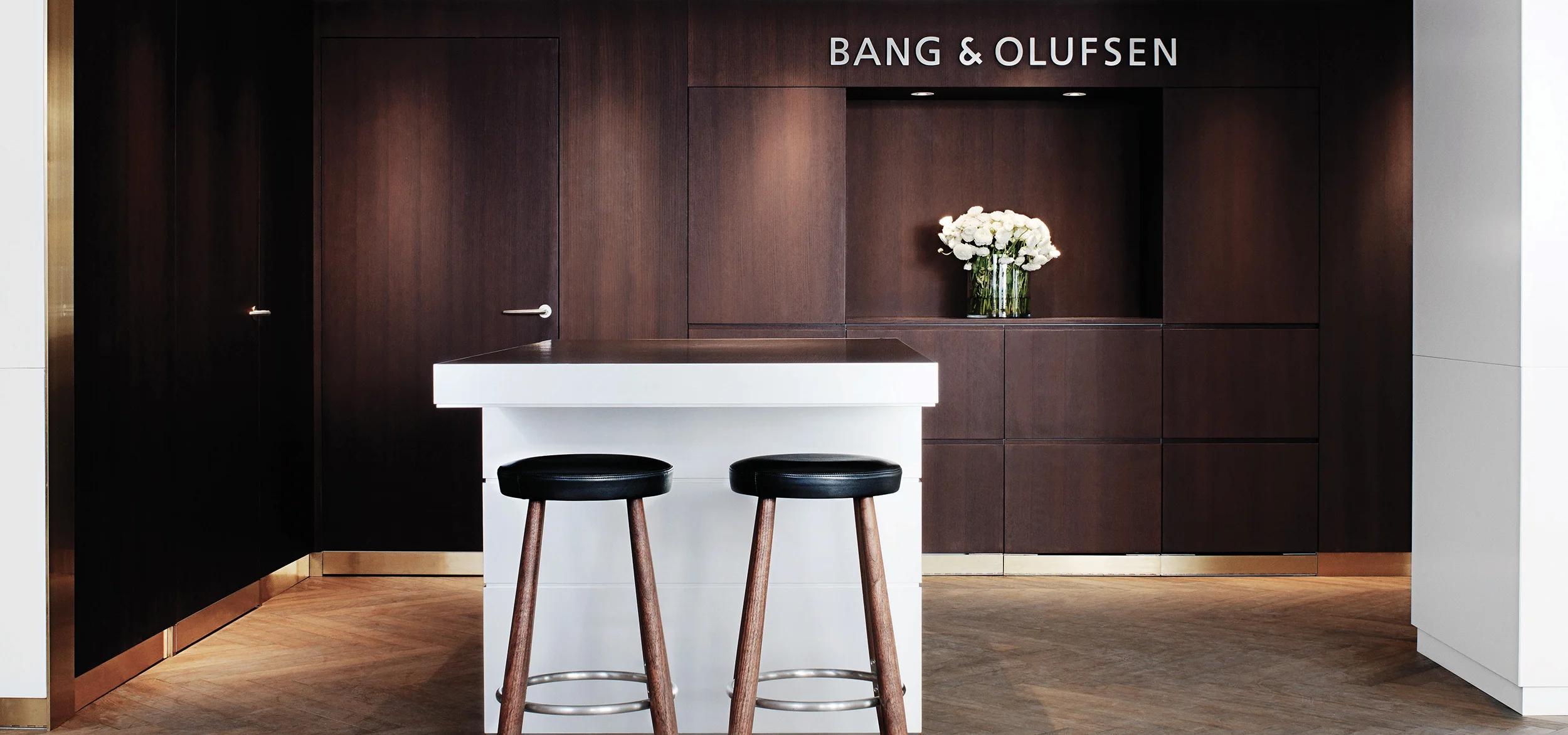 Two bar stools standing in front of white counter at Bang & Olufsen store in Copenhagen