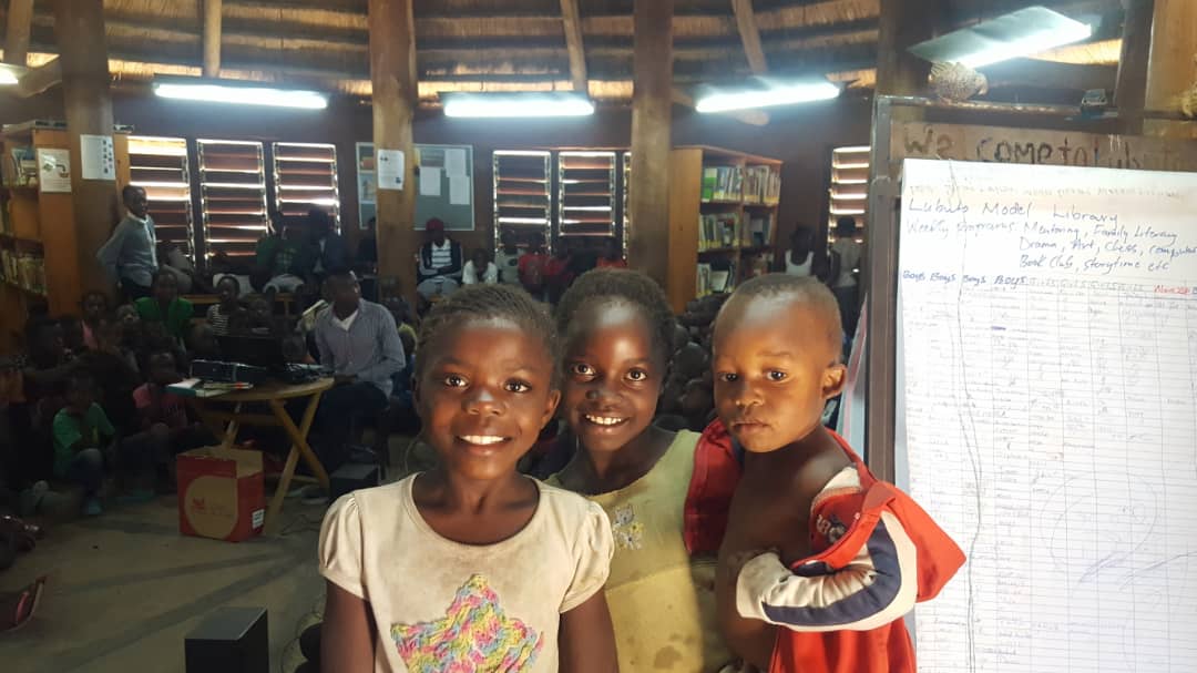 "We are sisters and this is our young brother. We always come for Friday movies here at the library. Our home has no electricity so we come to watch movies here. We've never watched today's movie, the Gods Must Be Crazy , but we are happy to see it."