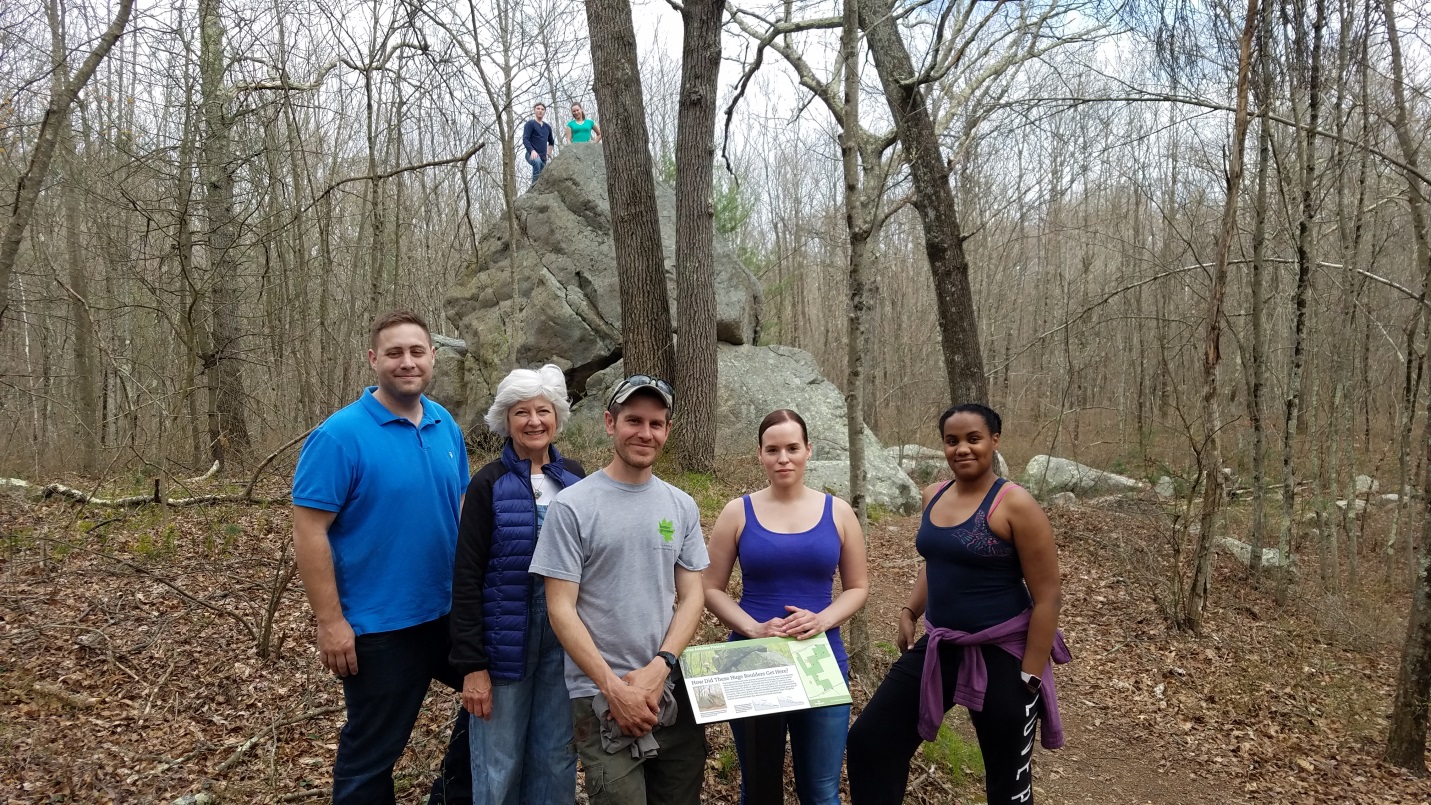 Massasoit students, professor Susan Martelli, and Wildlands Trust Property Manager Erik Boyer at the 20 ft. boulder, or "glacial erratic", at Brockton Audubon Preserve. 
