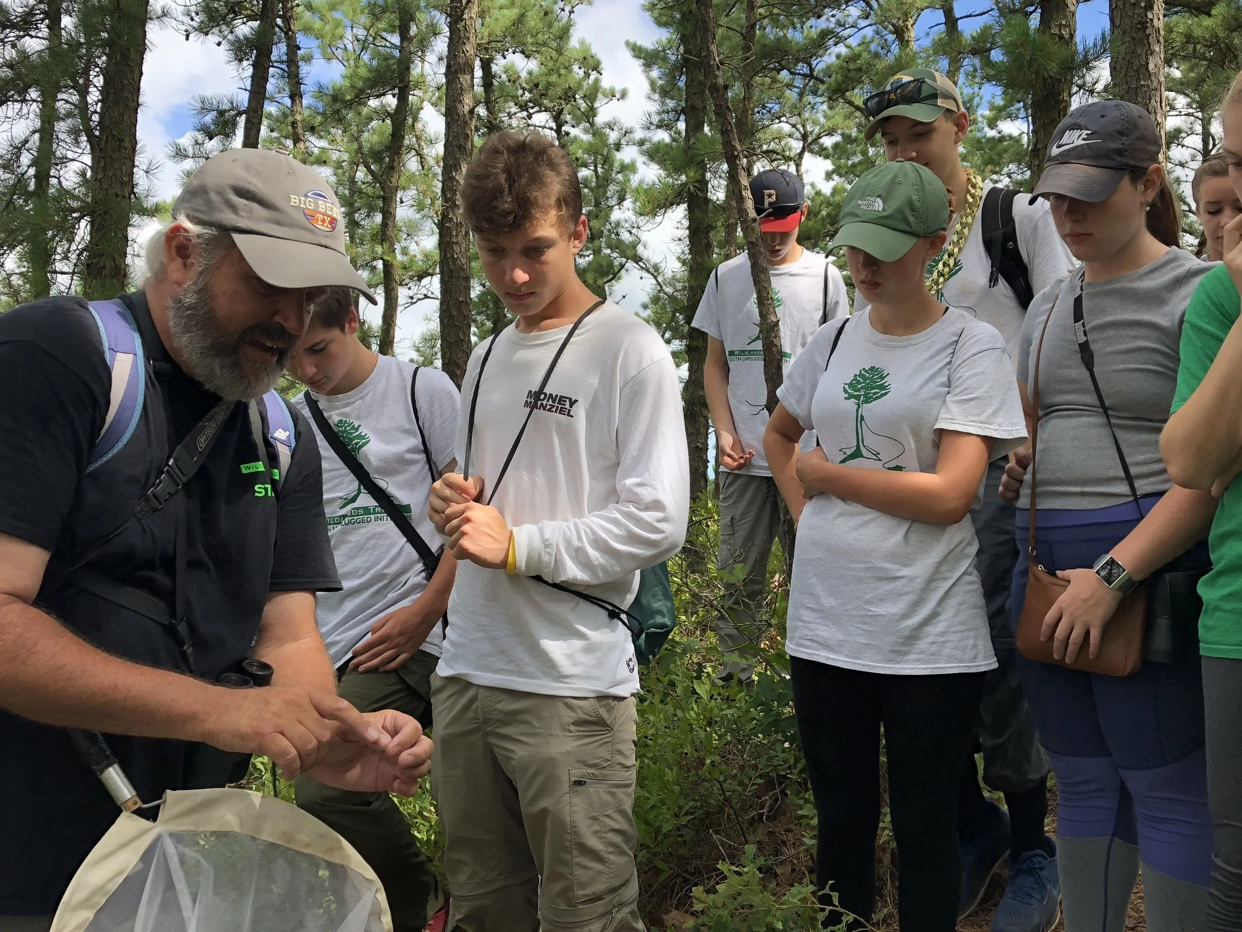 Green Team II crew members observe an insect with Naturalist Jim Sweeney at Great South Pond