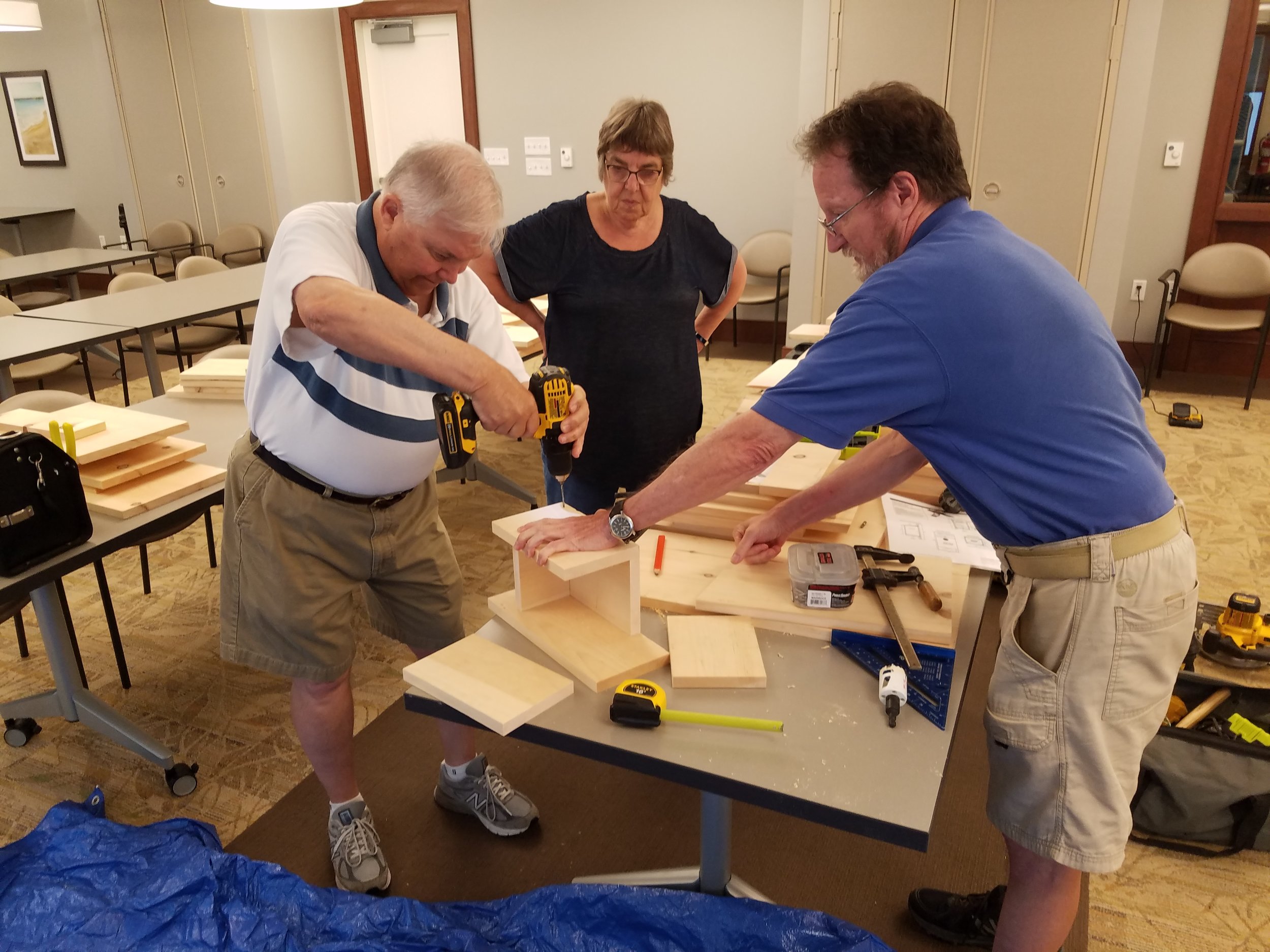 Residents of Fairing Way work together to construct a bluebird box.