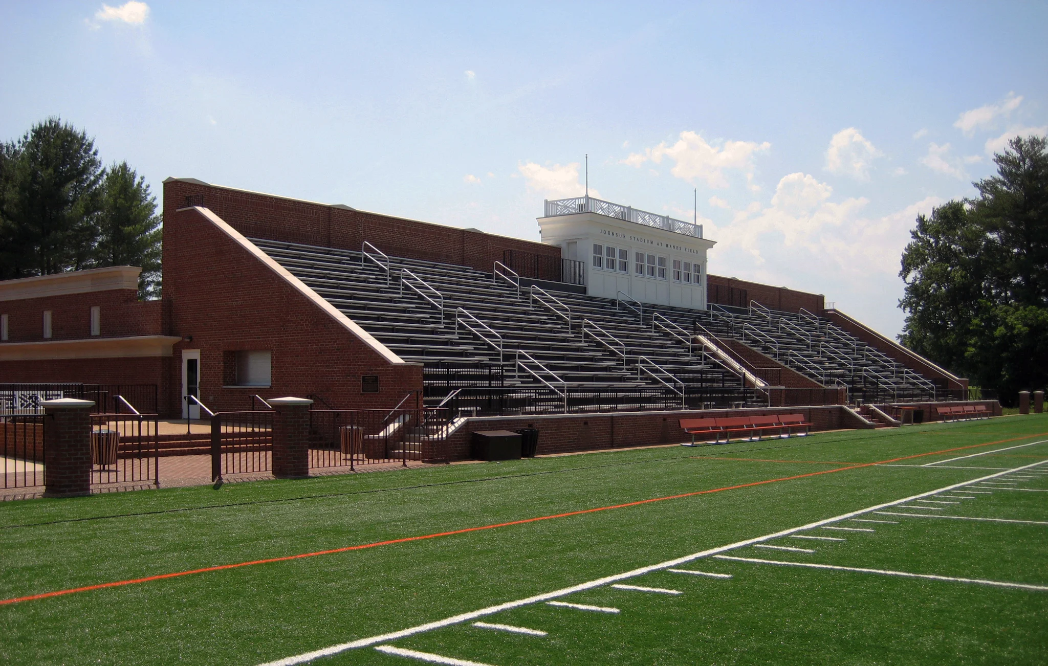 The Johnson Stadium and Squash Court facility is one part of an overall Athletic Master Plan designed by Bartzen + Ball for the Woodberry Forest School in Orange, Virginia. The Stadium project includes a total of 1,160 seats, a new press box, concessions area, public restrooms and storage facility. Under the seating area, a new sports memorabilia and awards space highlighting Woodberry Forest’s athletic history allows for gatherings throughout the year. Behind the existing Hanes Field House and adjacent to the stadium, a new courtyard has been added to accommodate events before or after football games. In the renovated building behind the stadium, nine new squash courts were added as well as a new practice basketball court, tiered spectator seating, a new ceiling, and new mechanical and electrical systems. Brick, precast concrete, and glass reference the architectural materials of the surrounding campus.
