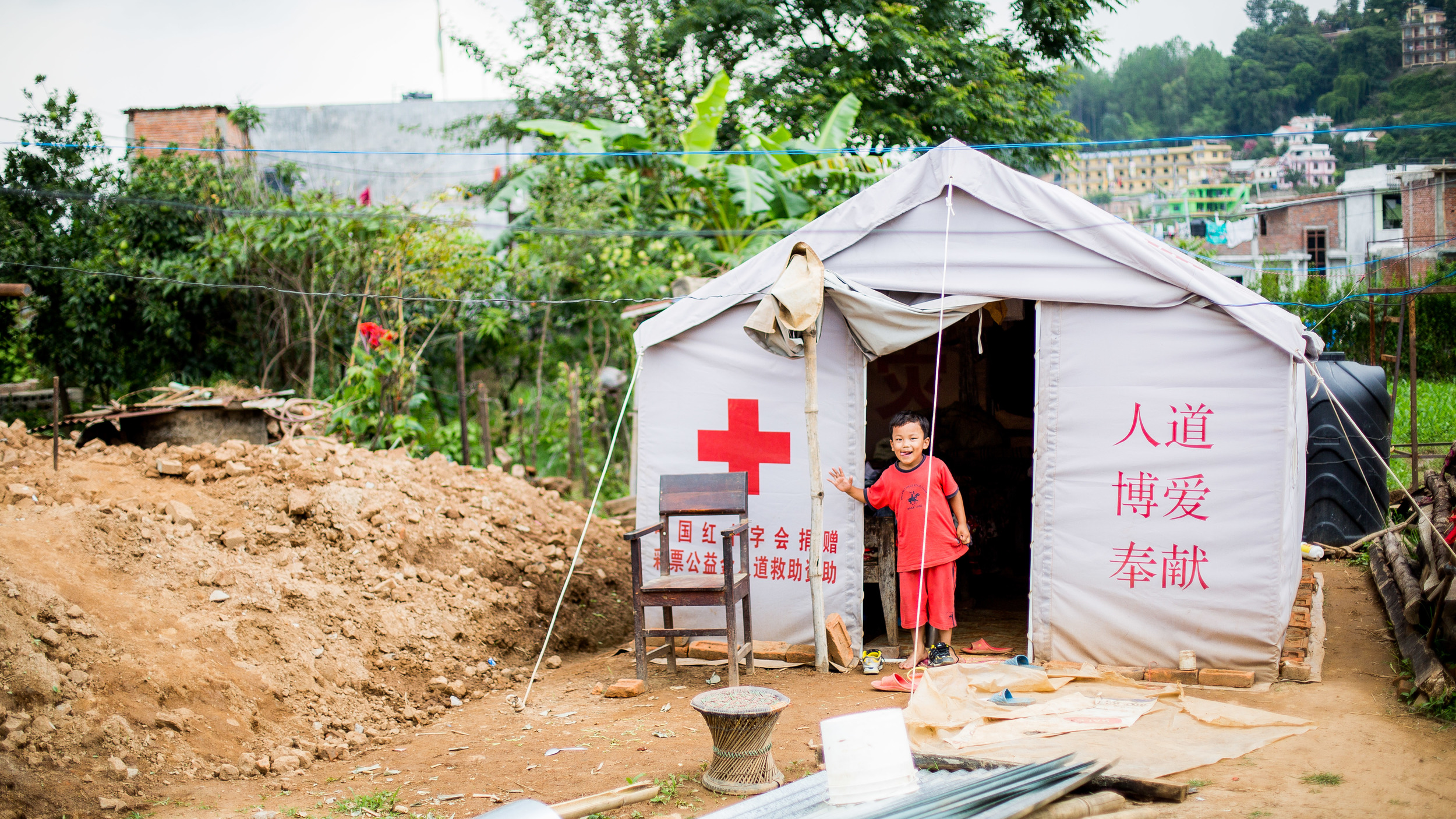 Little boy living with his parents in their temporary house this time provided by the Chinese Red Cross.