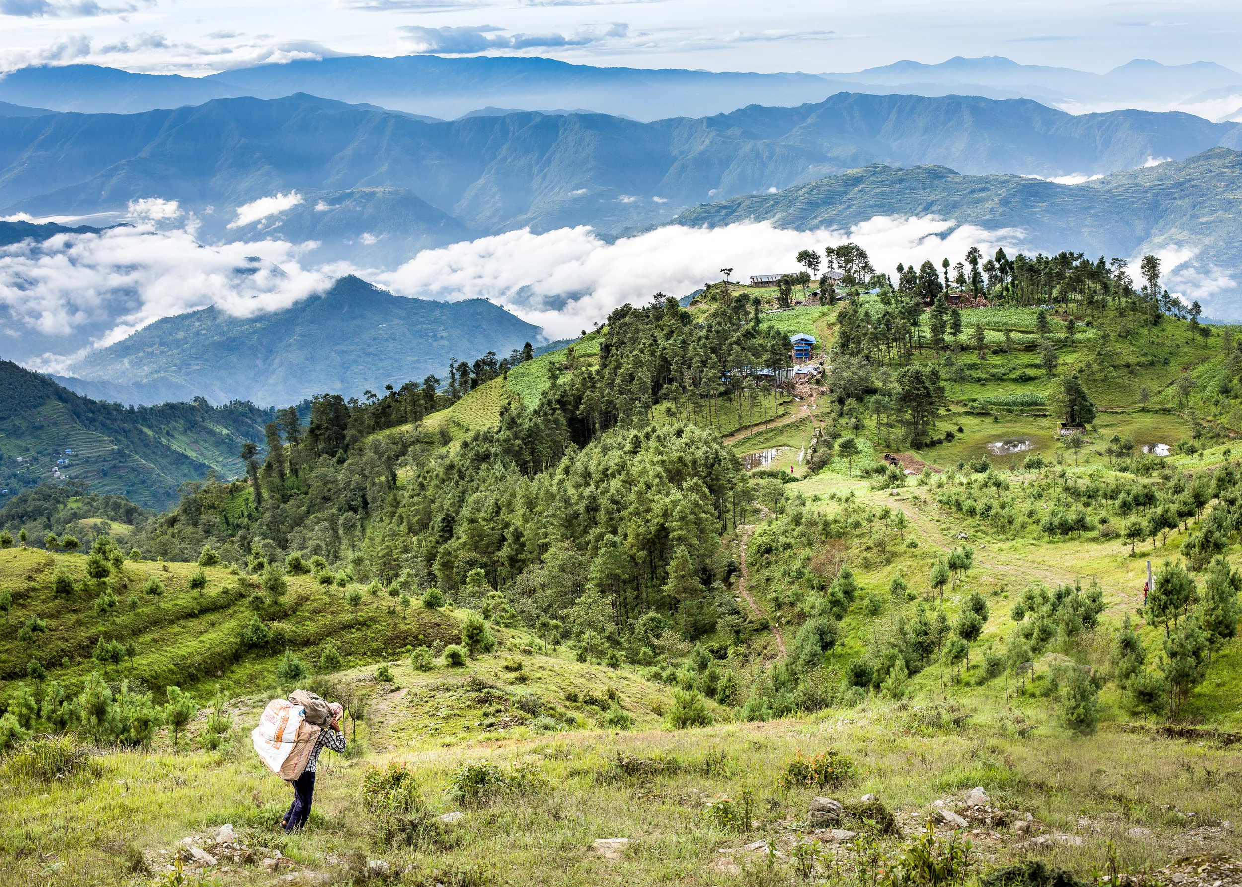 After a 2 hour walk, the magnificent view from the little village of Deorali. Our porter on his way down, carrying clothing to give to poor families and 2 laptops for local schools.
