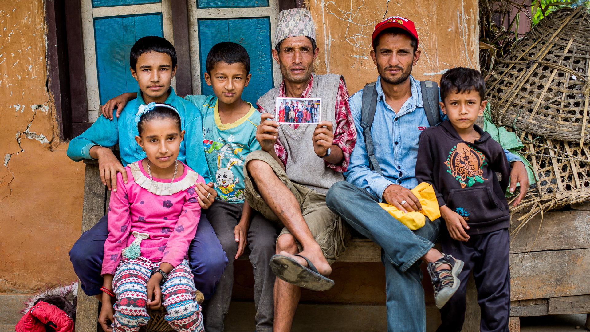 The headmaster of the poor Lower Primary School in Necha and his family posing with a photo taken at their school one year before. This school was almost completely destroyed in the earthquake. 