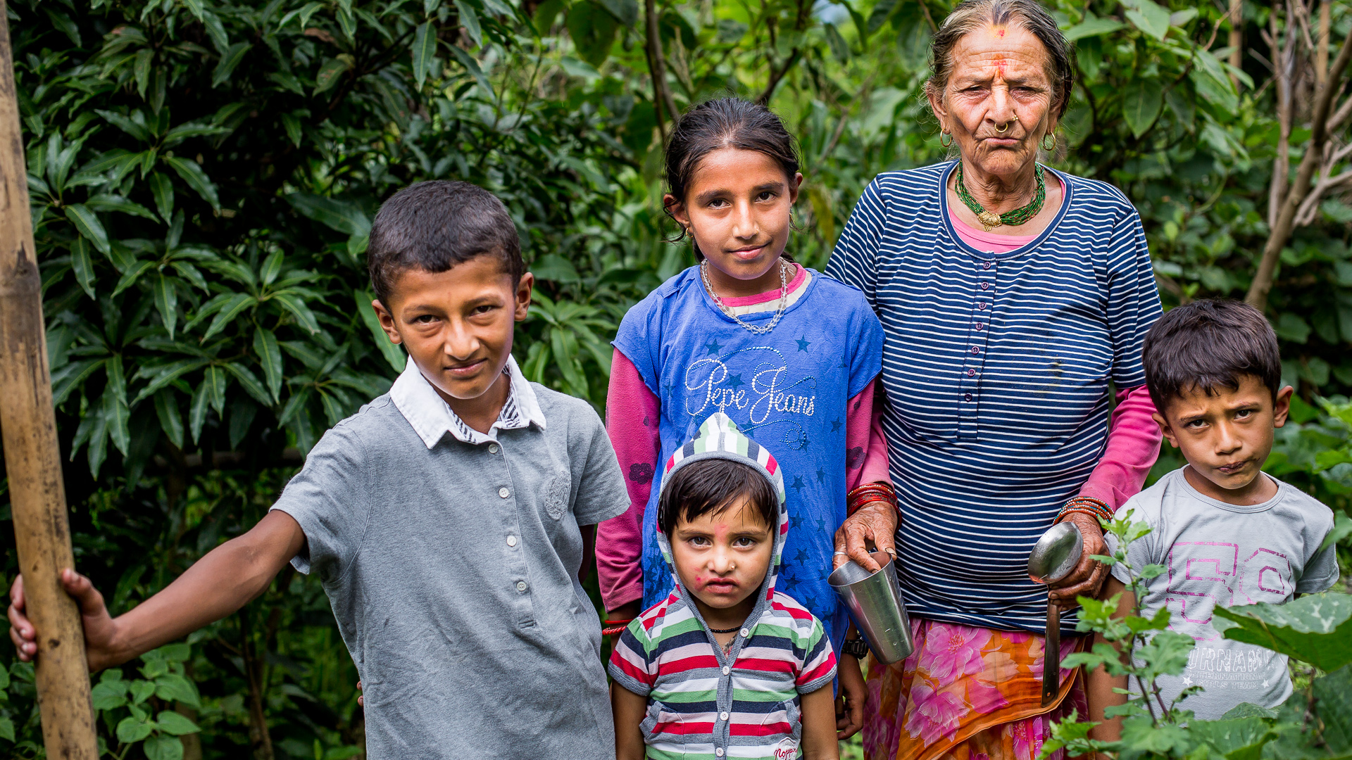 Group of children with their grandmother wearing new clothes provided by Micro-Care Nepal Foundation. 