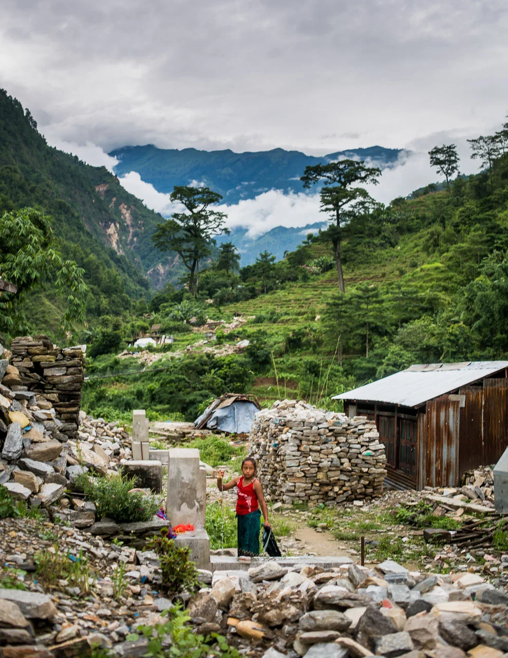Child taking water from a tap in what was the main street of the village.