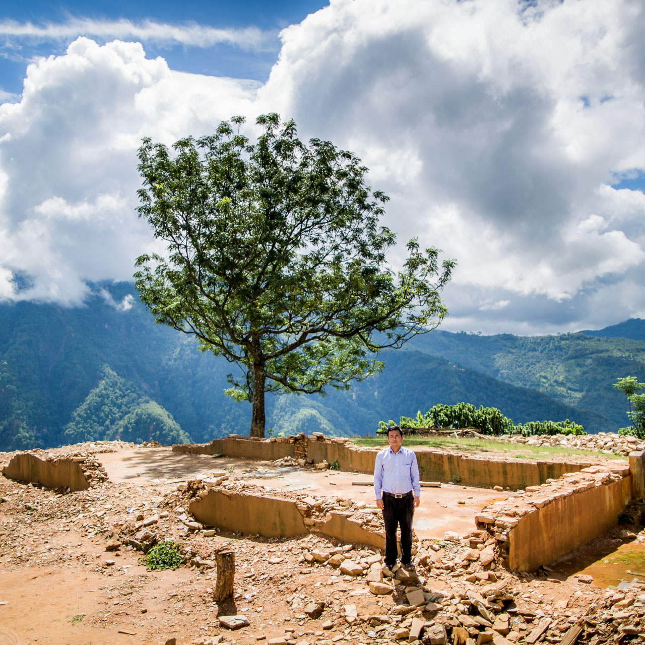 The principal of the Shree Himalaya Higher Secondary School standing amongst all that remains of their once beautiful school building.