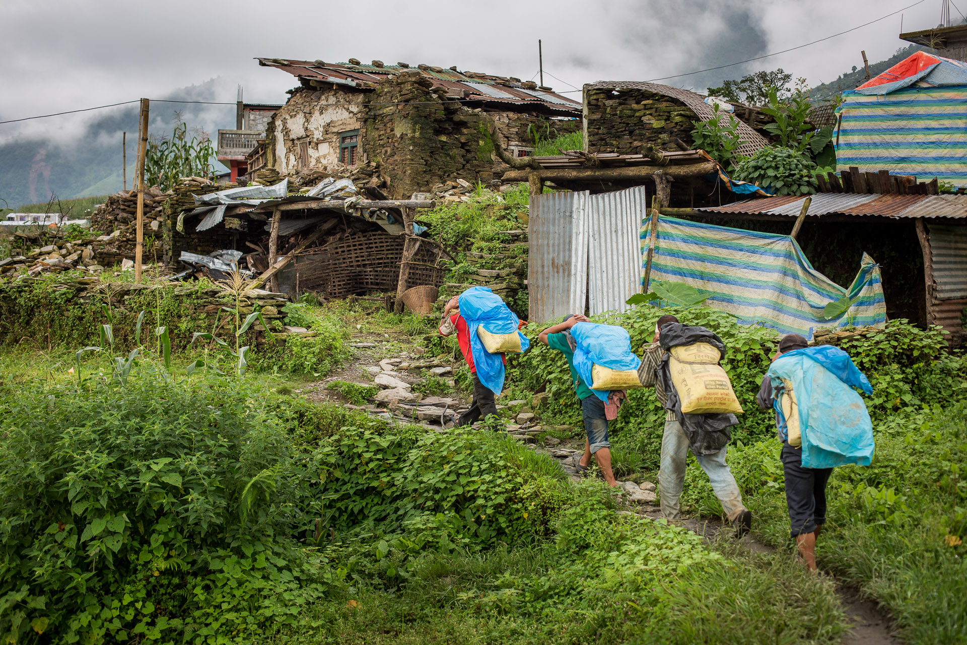  Group of porters carrying cement up to slowly start reconstructing their houses. 