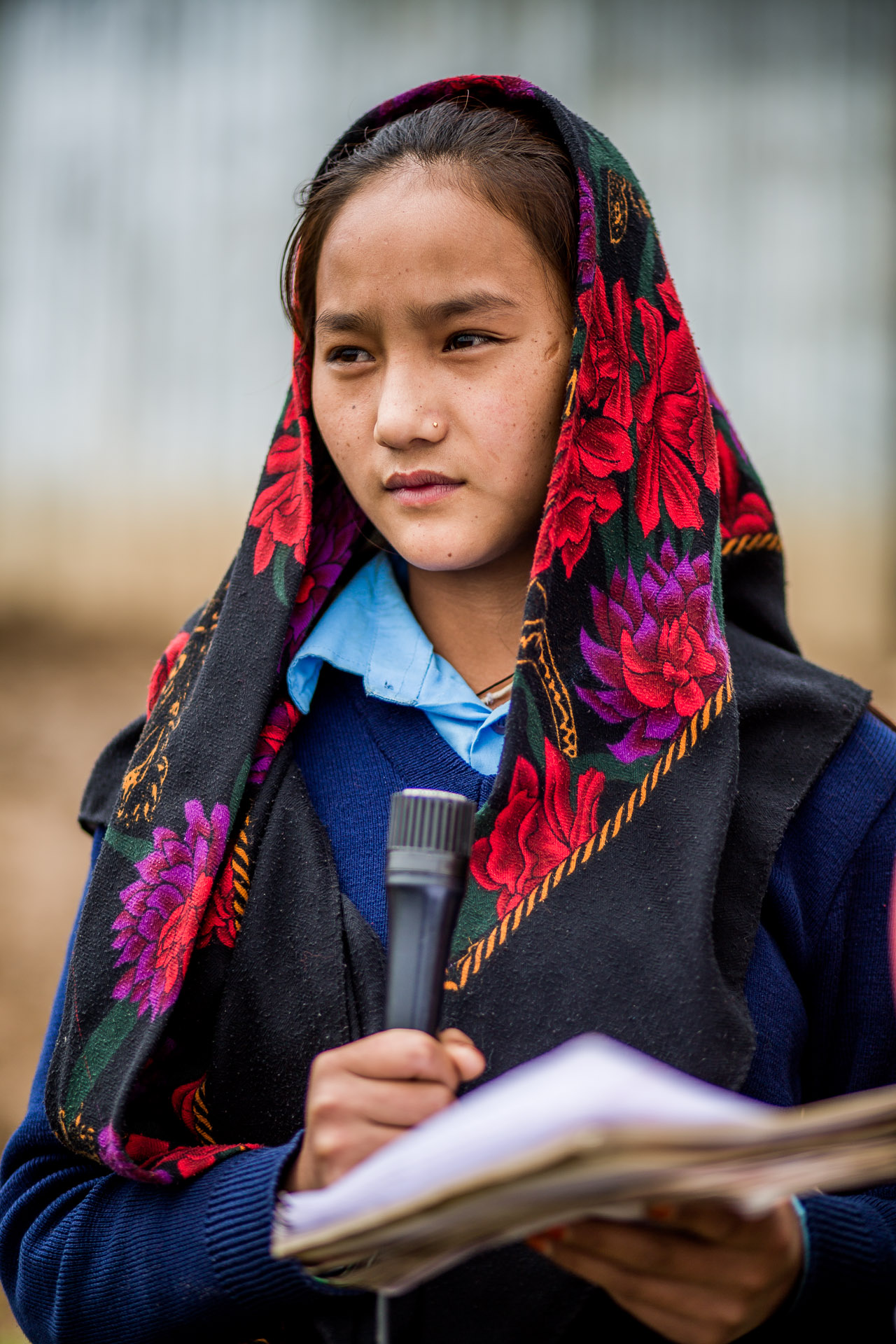 Girl reading her schoolwork as part of the morning assembly to the other 200 students.