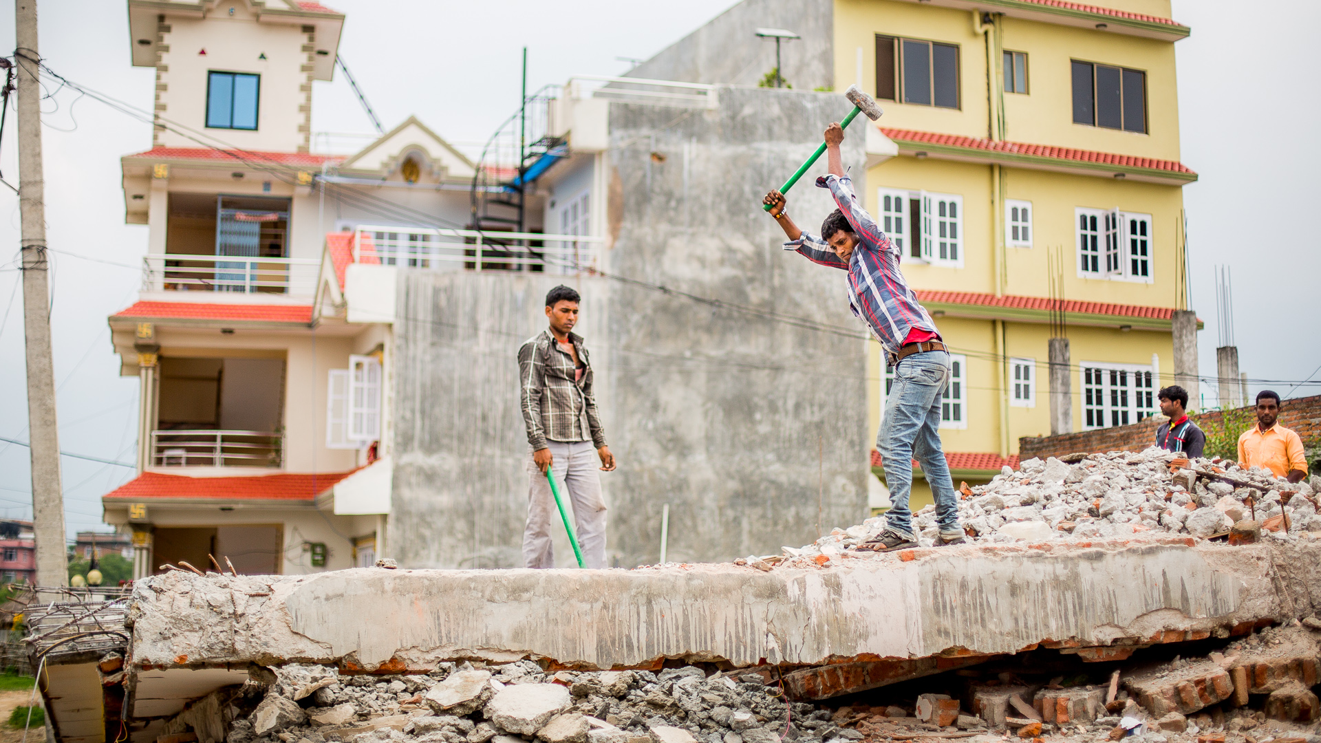 Demolishing concrete floors by hand that had collapsed during the earthquakes.