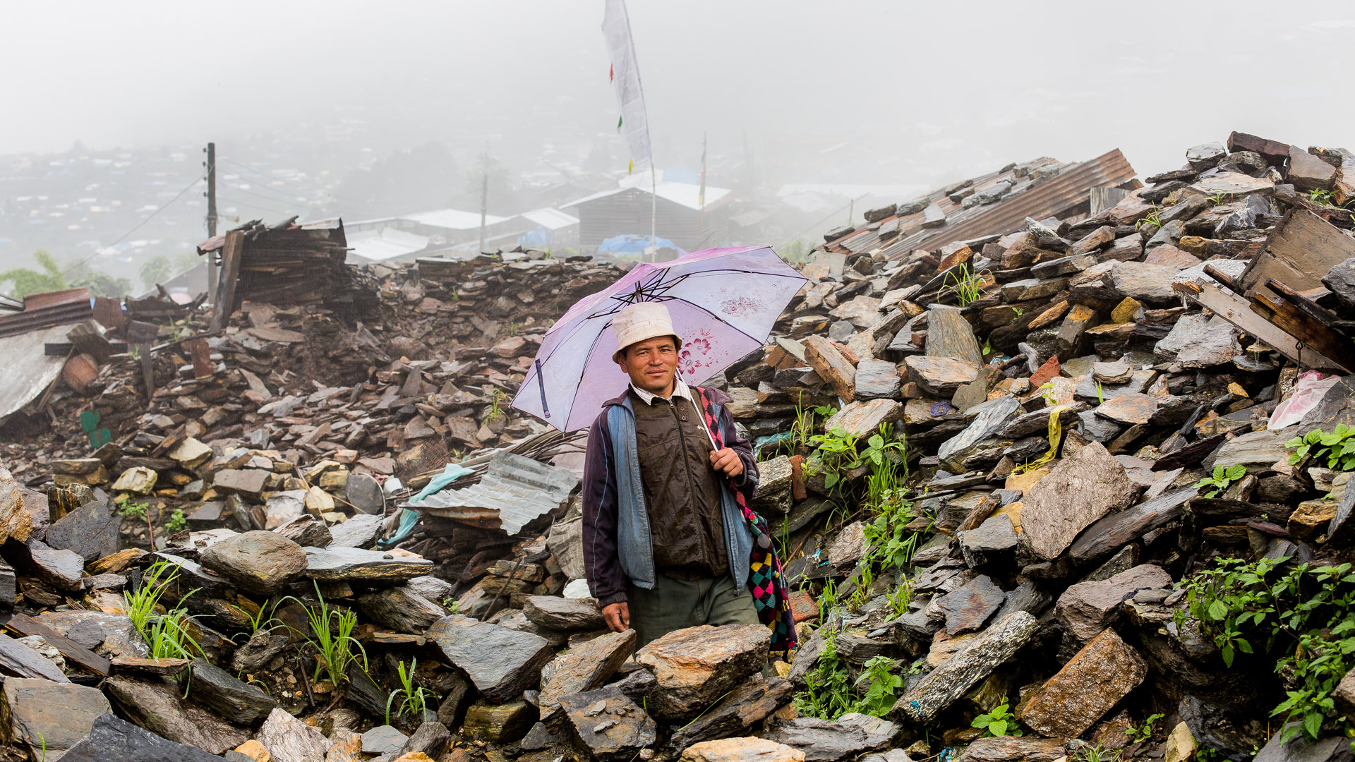 Villager of Barpak walking around in the area where their village was and now is a warbled of ruins. 