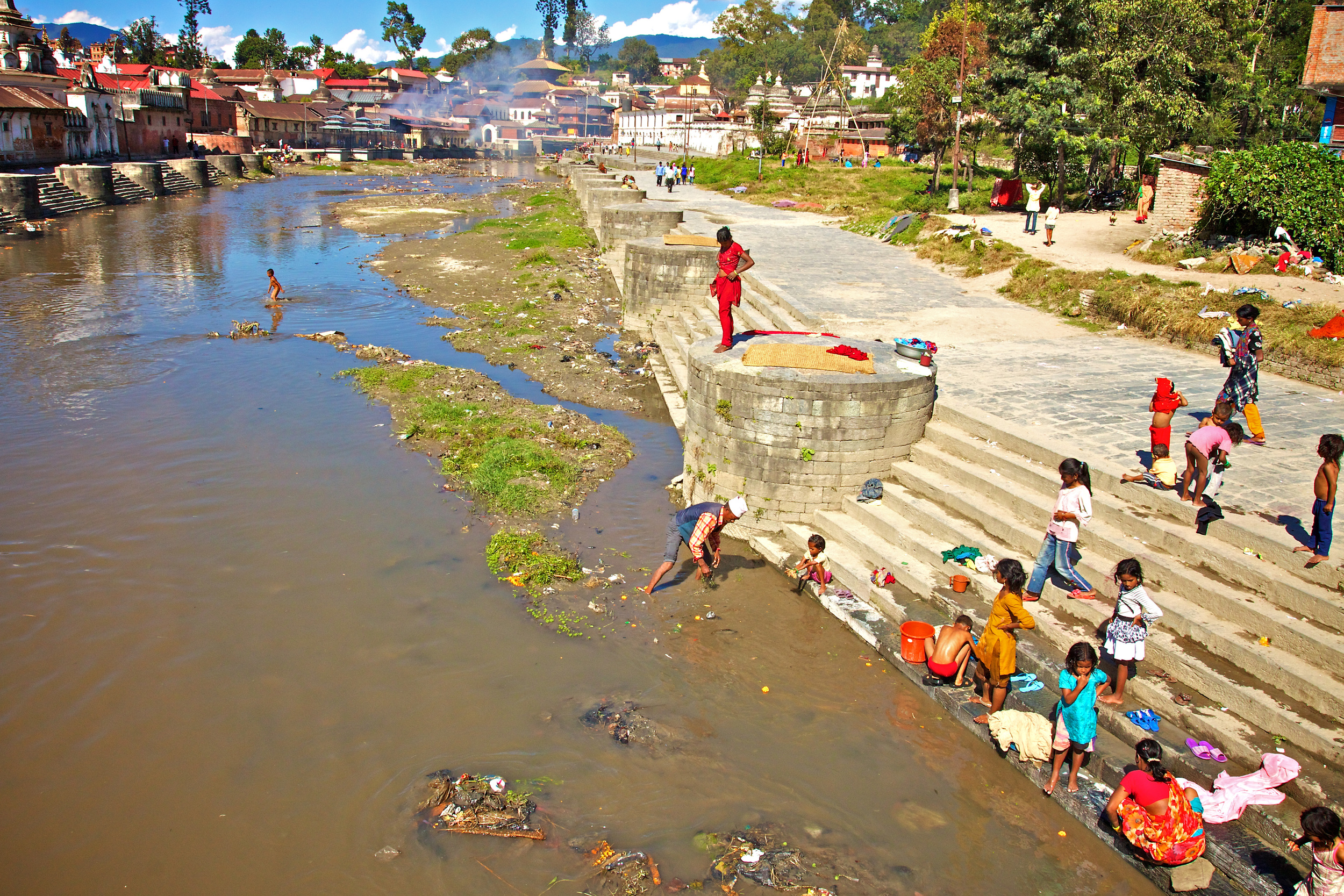 De rivier bedding van de heilige Bagmati rivier met in de verte de Pashupatinath tempel waar de Hindoeïstische crematies plaatsvinden. 