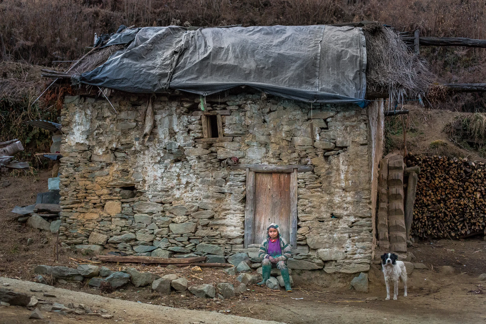 Sumit Tamara sitting infront of his house in Sitola in Far-West Nepal.