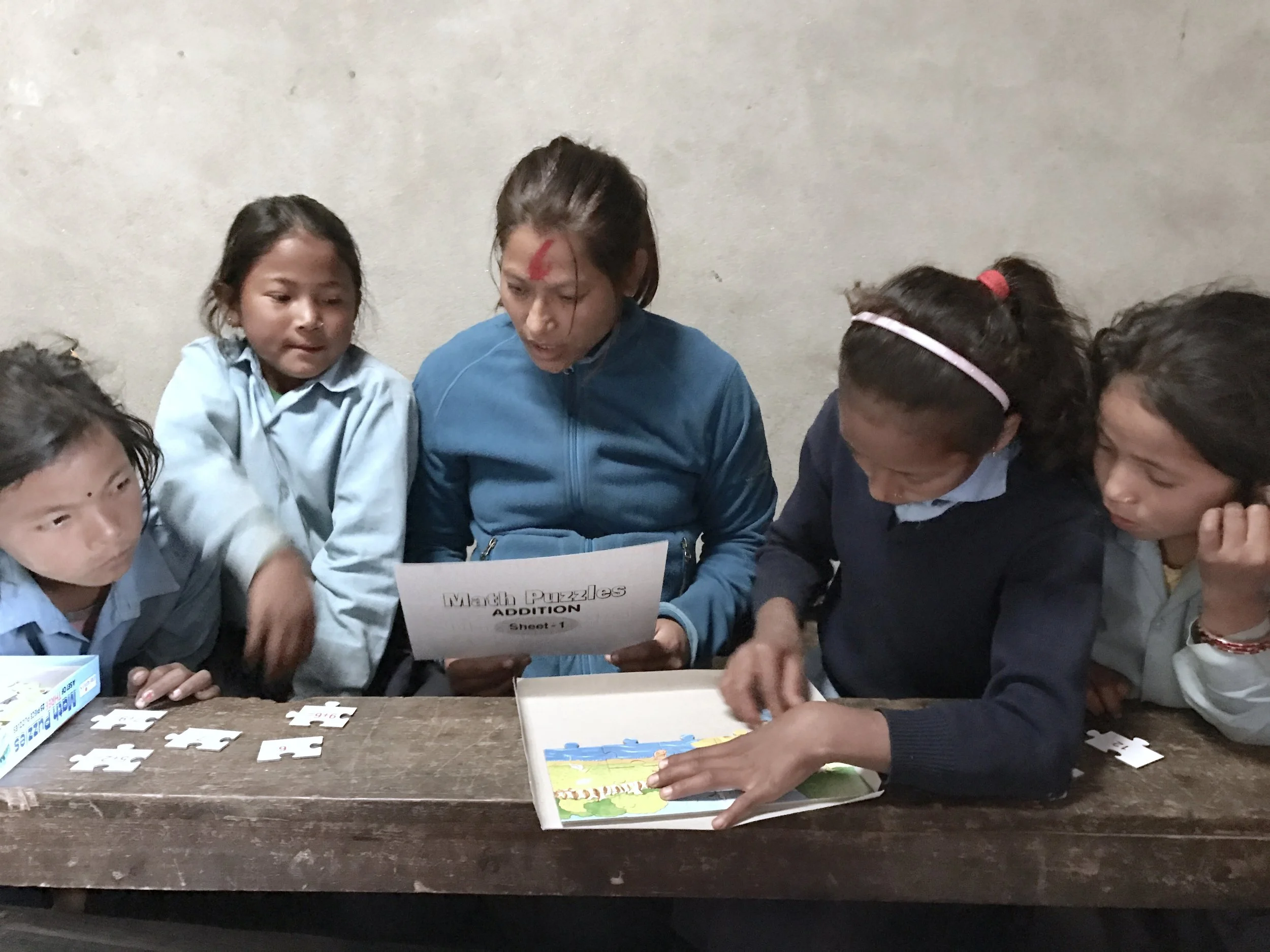Teaching together with local teachers to introduce and learn them how to use the school materials provided by Micro-Care Nepal.