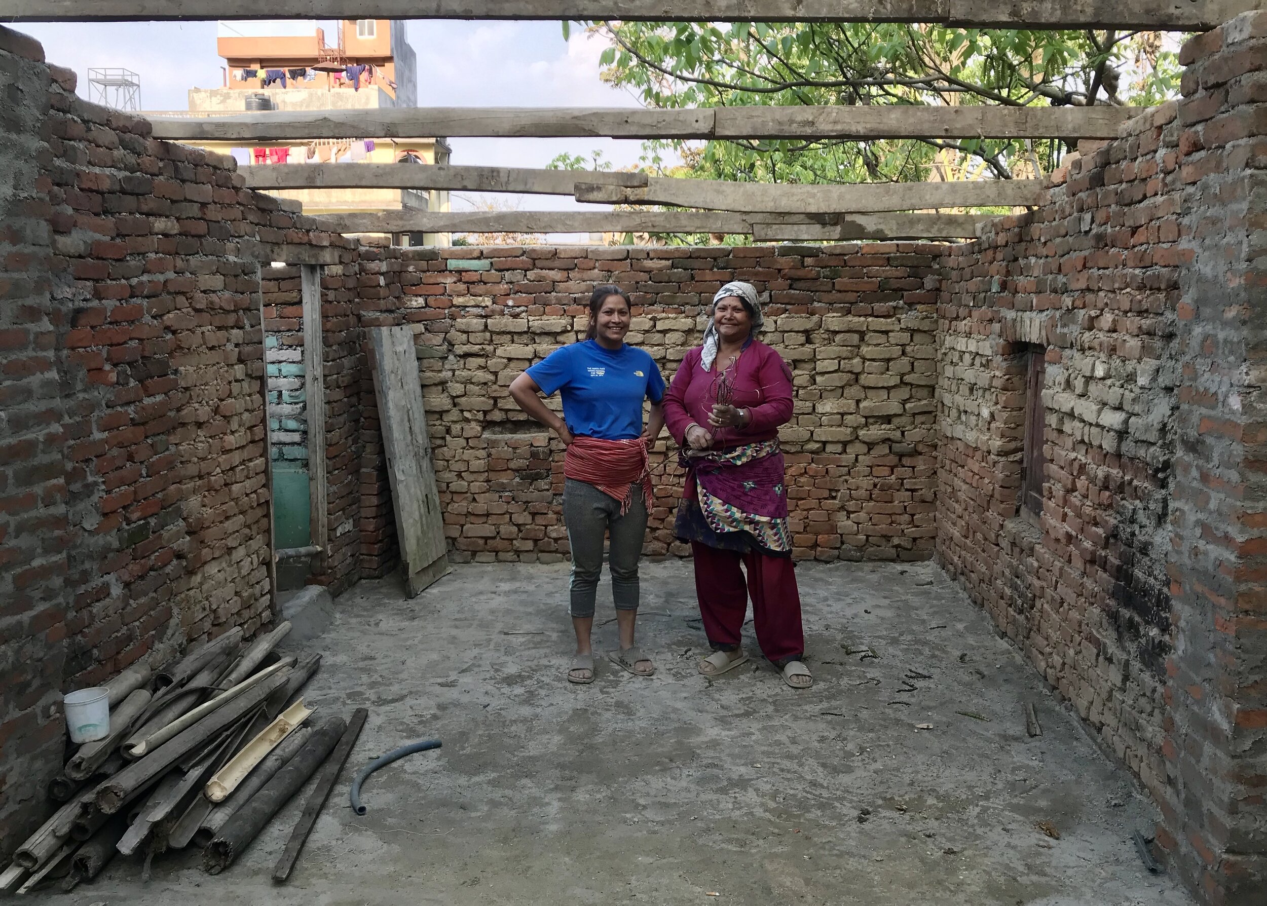  Samjhana en haar moeder poseren in de nieuwe garage na het plaatsen van de eerste balken. 