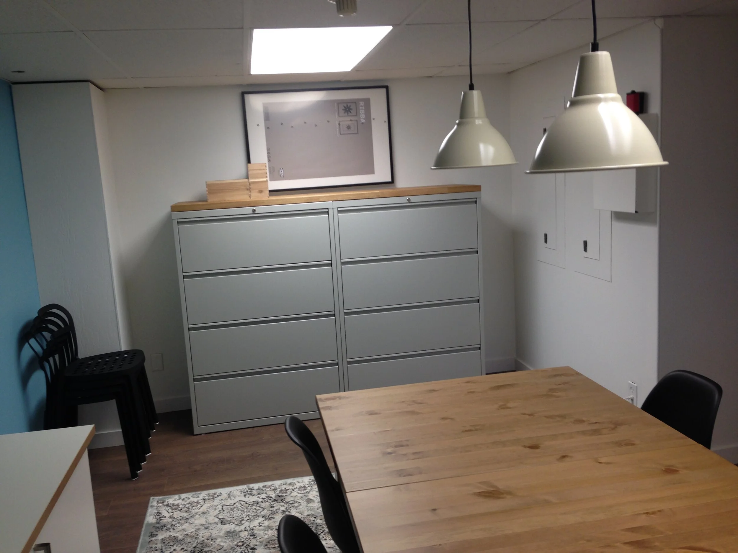 Commercial filing cabinets in a pale grey colour with wood top to give the feeling of a built-in cabinet.