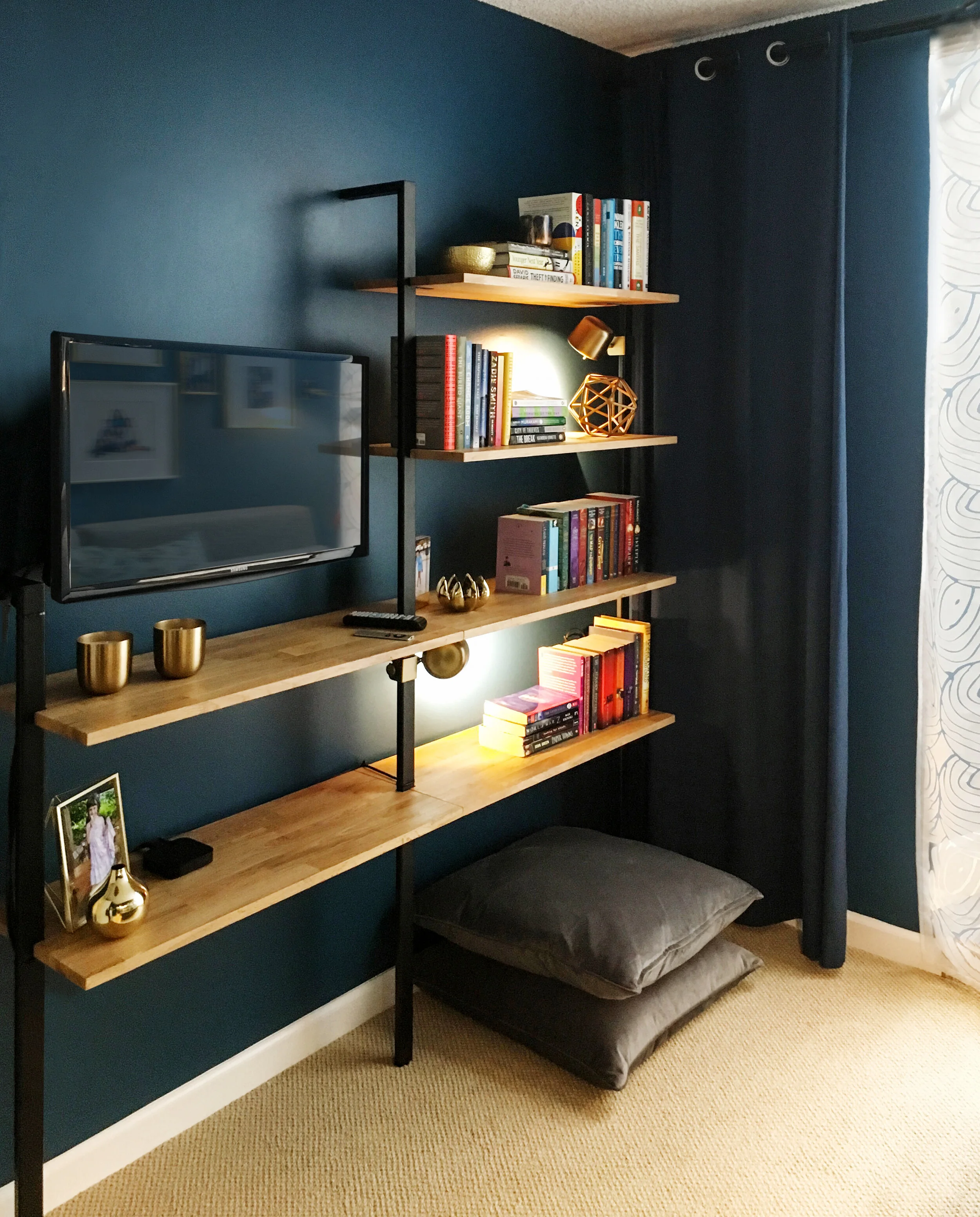 Very narrow built-in bookshelf with dark blue wall.