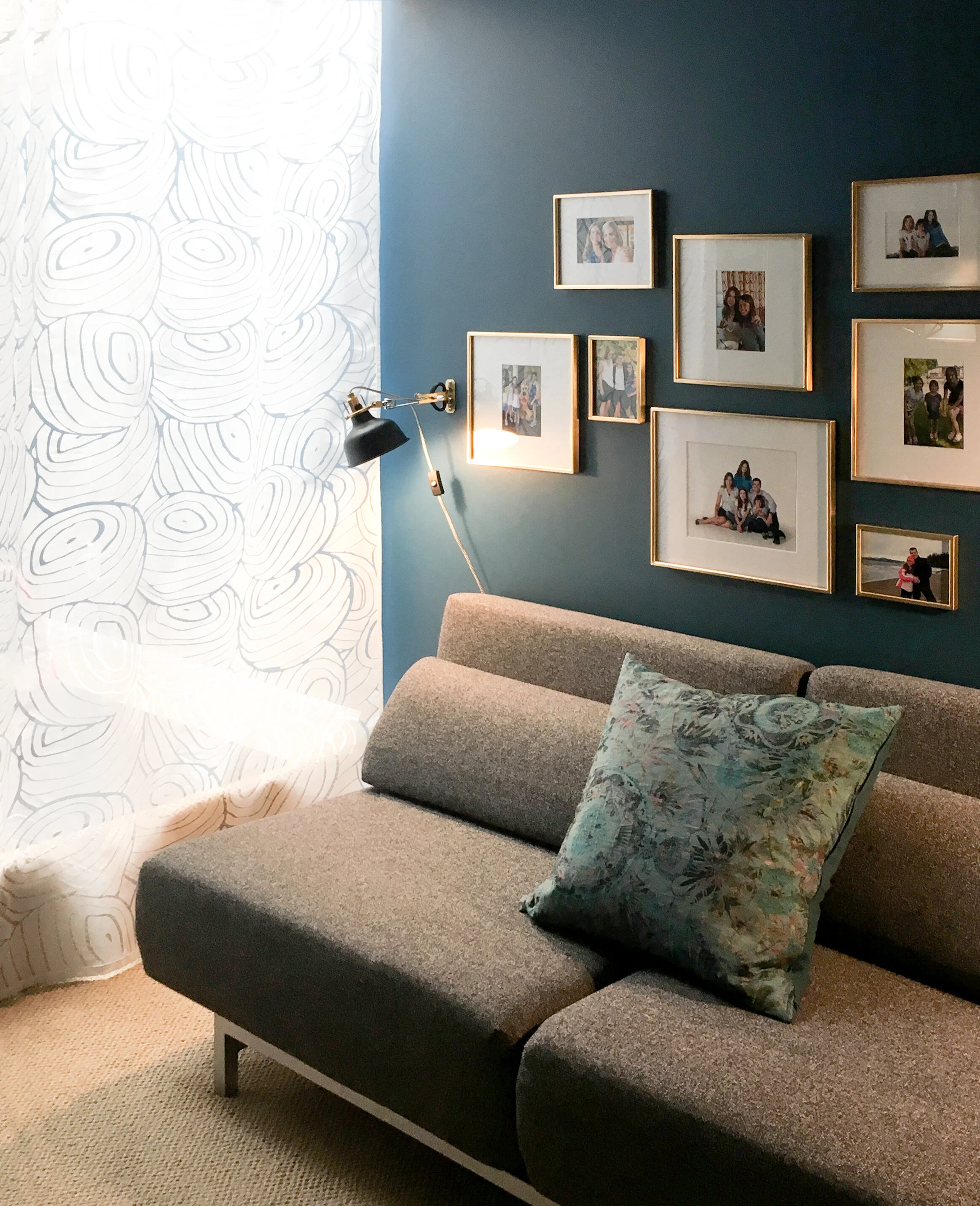 Sofabed with sheer curtains and reading light.