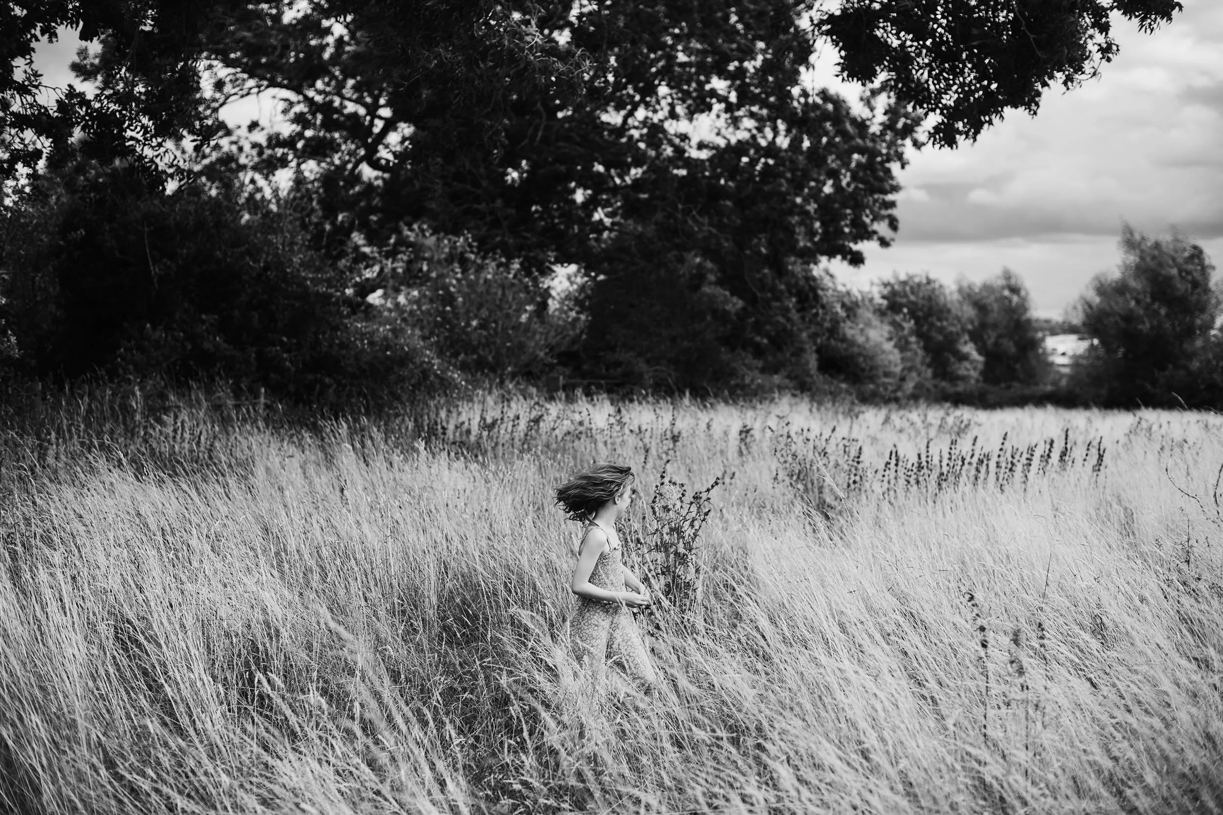 Standing still at the edge of the long grass, everything else seems to fall away.

Out ahead, children run freely through the golden filed - laughter breaking through the air as they chase each other without purpose or pause. The grass moves with the