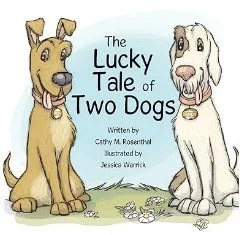 Cover of a book titled 'The Lucky Tale of Two Dogs' featuring two cartoon dogs, one tan with a pink collar and one white with black spots, sitting on grass with flowers.