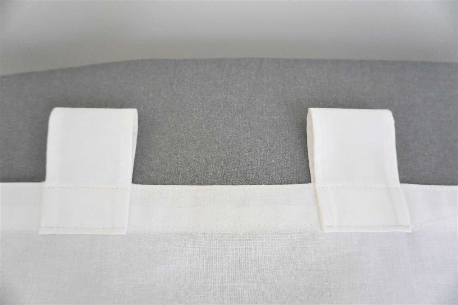 Loops with two rows of topstitching, one on the curtain edge and one at the loop edge that extends 1 inch into the curtain panel