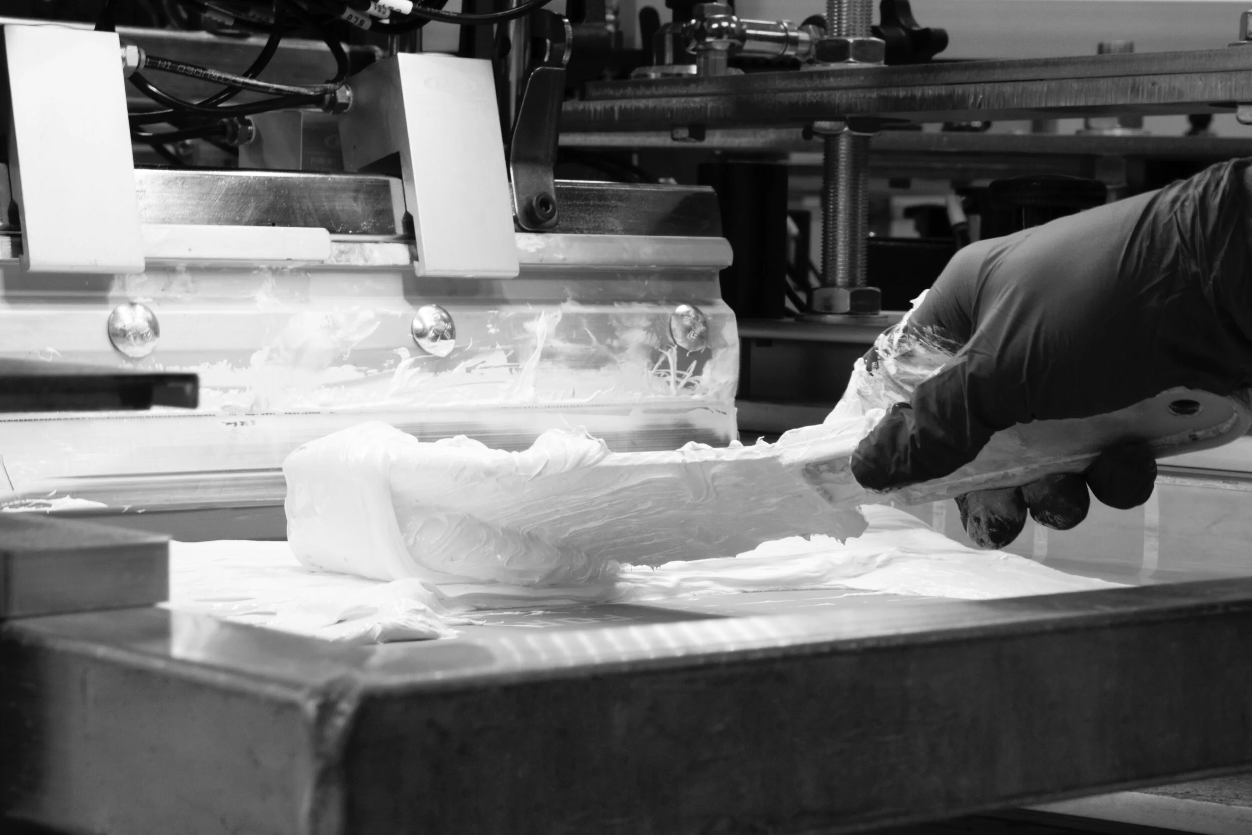  One of our screen printing technicians adding ink to a print station. 