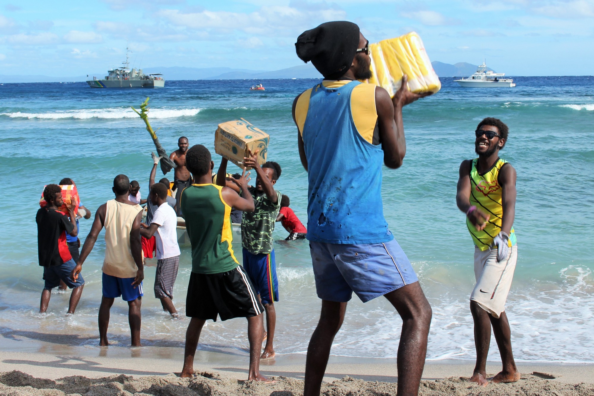 Community Members unloading food supplies and NFI kits in Mataso Island, Vanuatu (Alberto Preato / IOM)