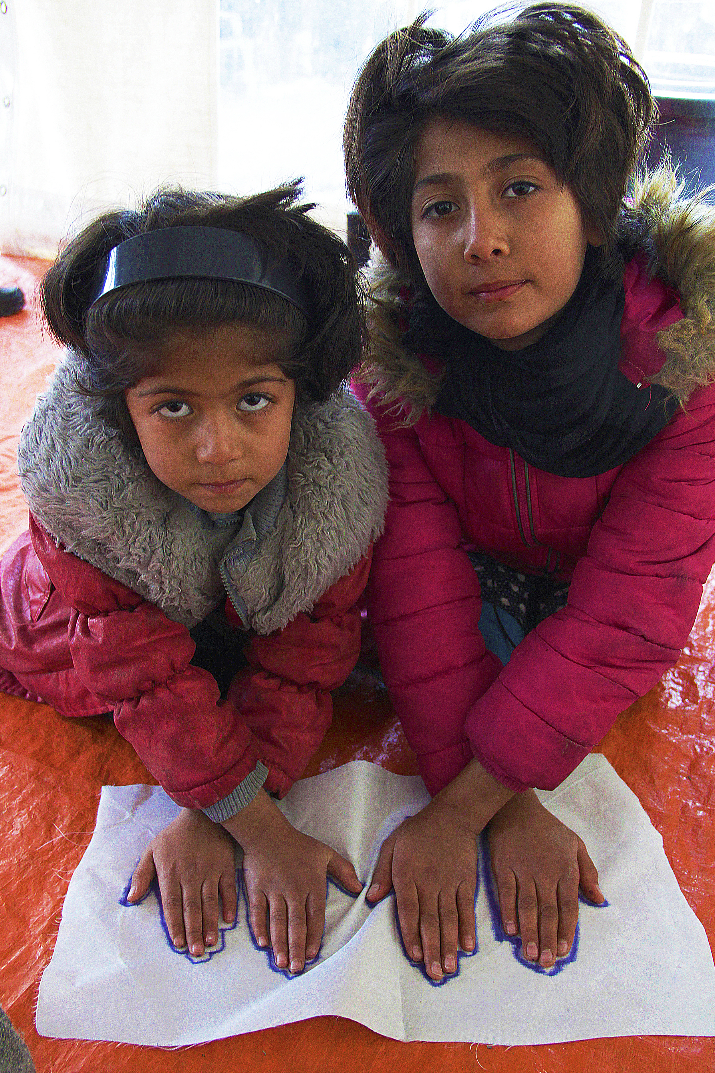 Two sisters hand's traced at Children's Protection Play Center at Refugee Camp Better Days for Moria, 2015. Photo courtesy of artist.
