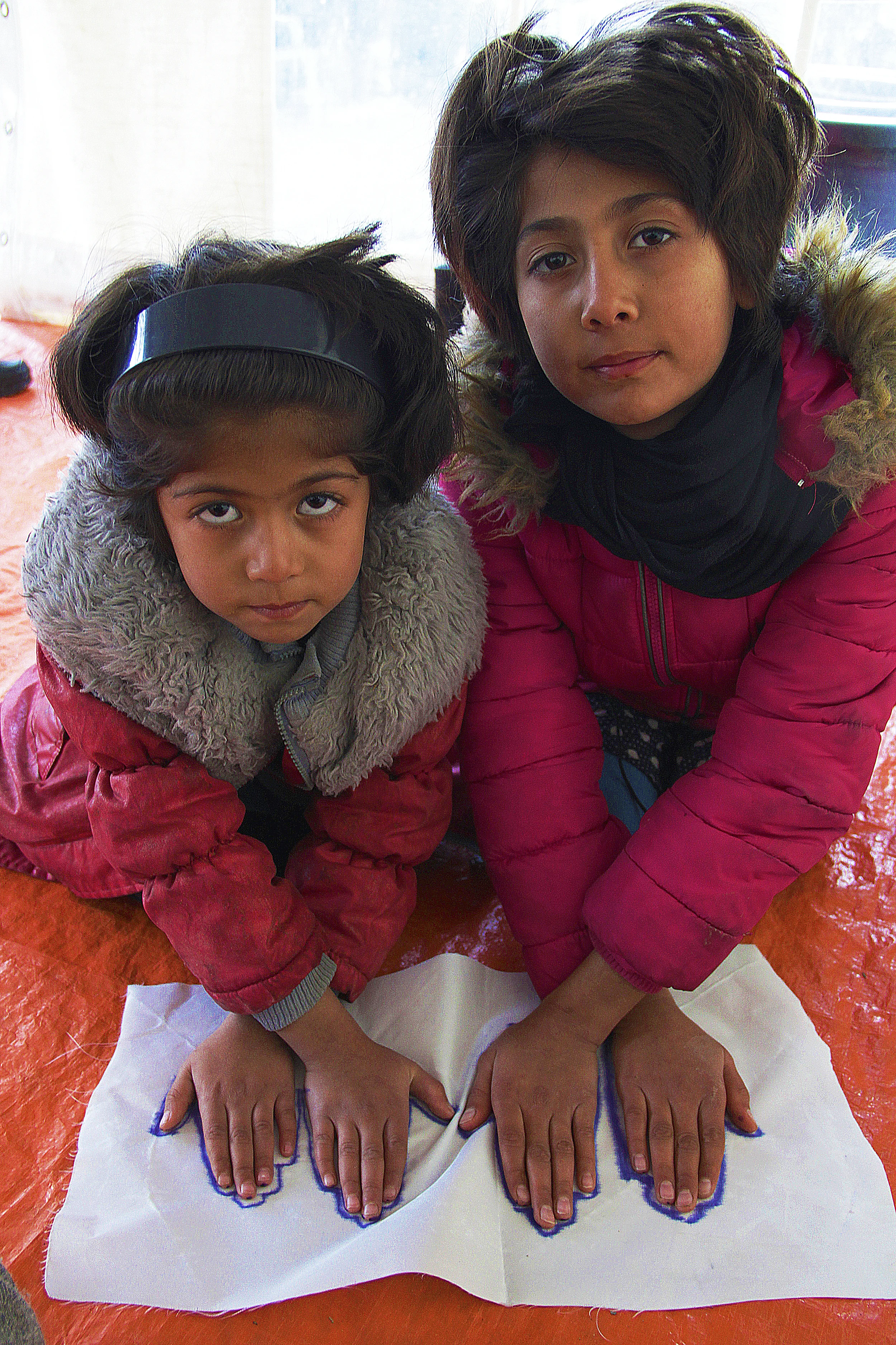 Two sisters hand's traced at Children's Protection Play Center at Refugee Camp Better Days for Moria, 2015. Photo courtesy of artist.