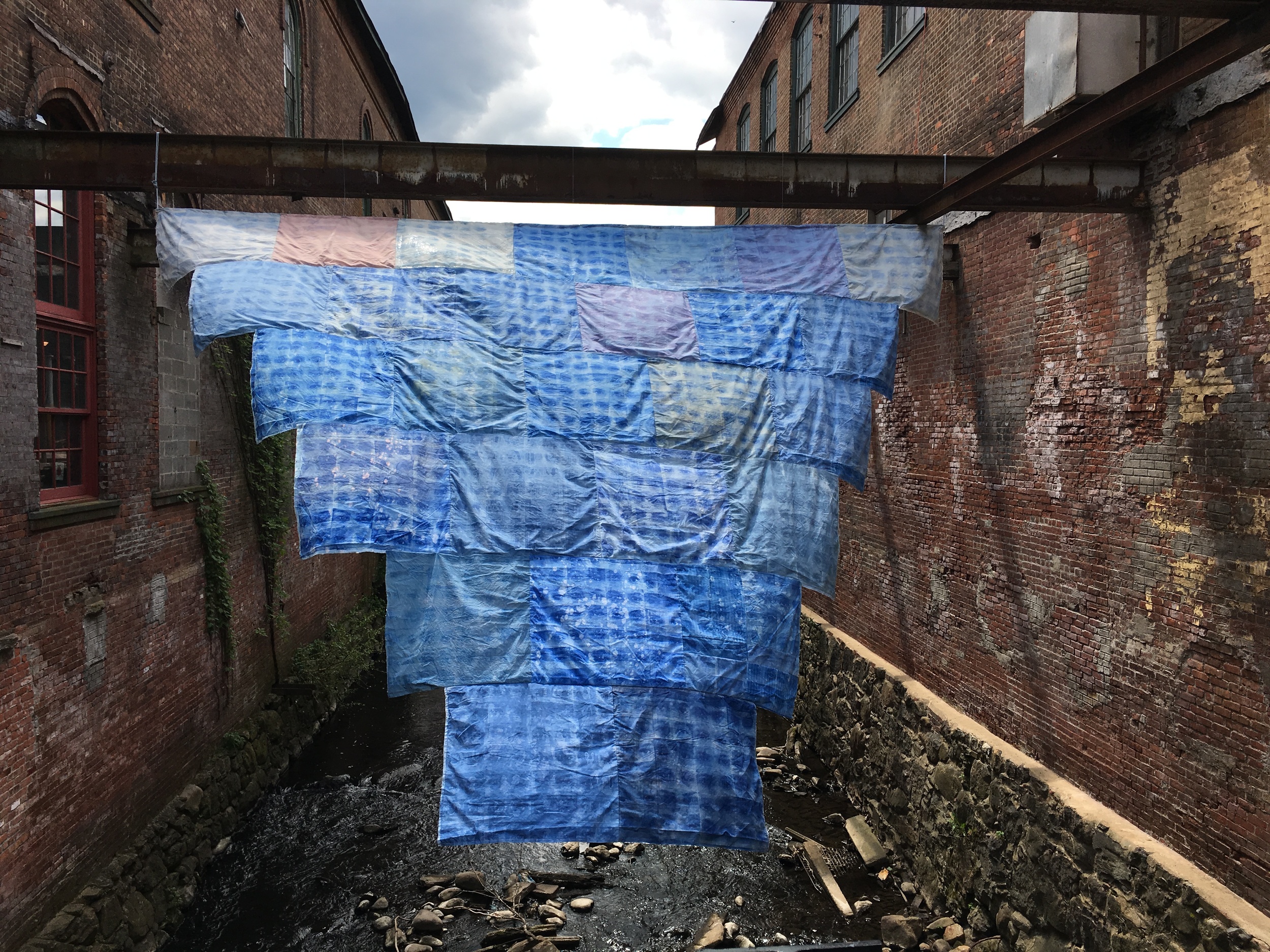 Installation of 'EYES for EYES (Prototype)' at Garner Arts Center, 2016, photosensitive dye on old linens and emergency blankets, 21' x 18'. This work is kinetic and dynamically luminescent depending upon light. 