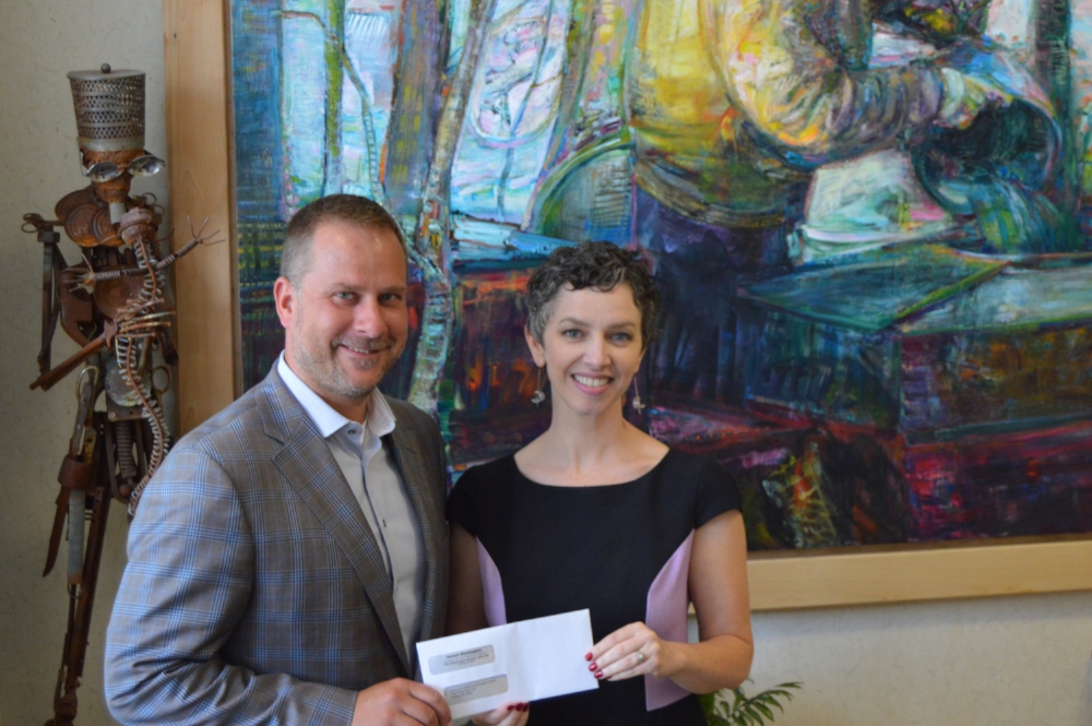 Resch Strategies president Matt Resch presents the scholarship check to Lansing Art Gallery director Barb Whitney