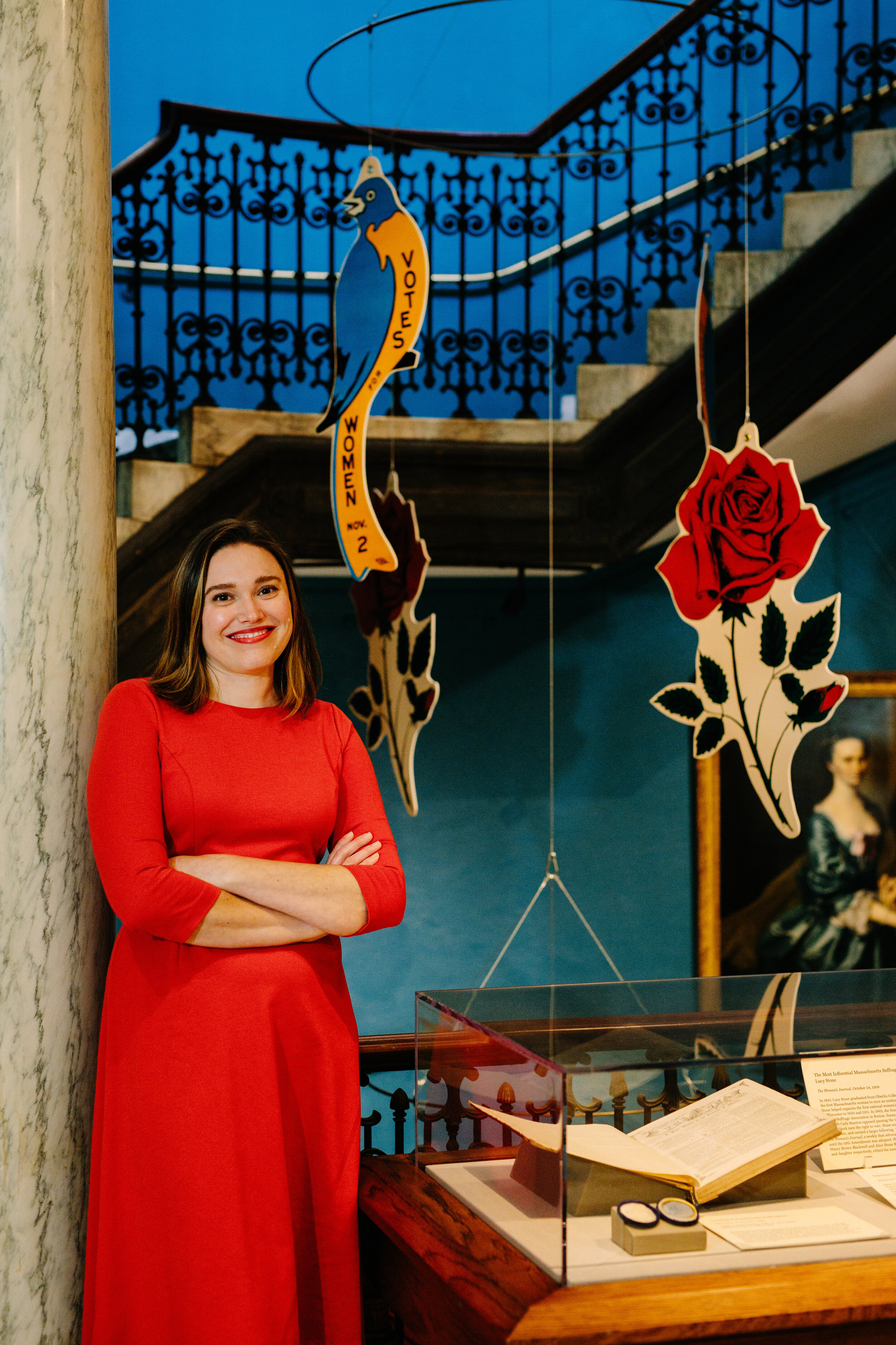 Allison stands with one of her favorite features of the exhibition, a suffrage bluebird and anti-suffrage rose mobile