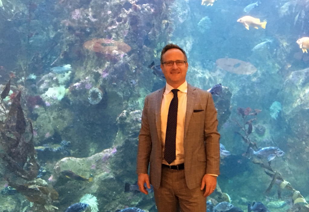 Above: Dean Jones, President & CEO of Realogics Sotheby’s International Realty, stands in front of a massive aquarium that served as a dramatic backdrop during the panel discussion.